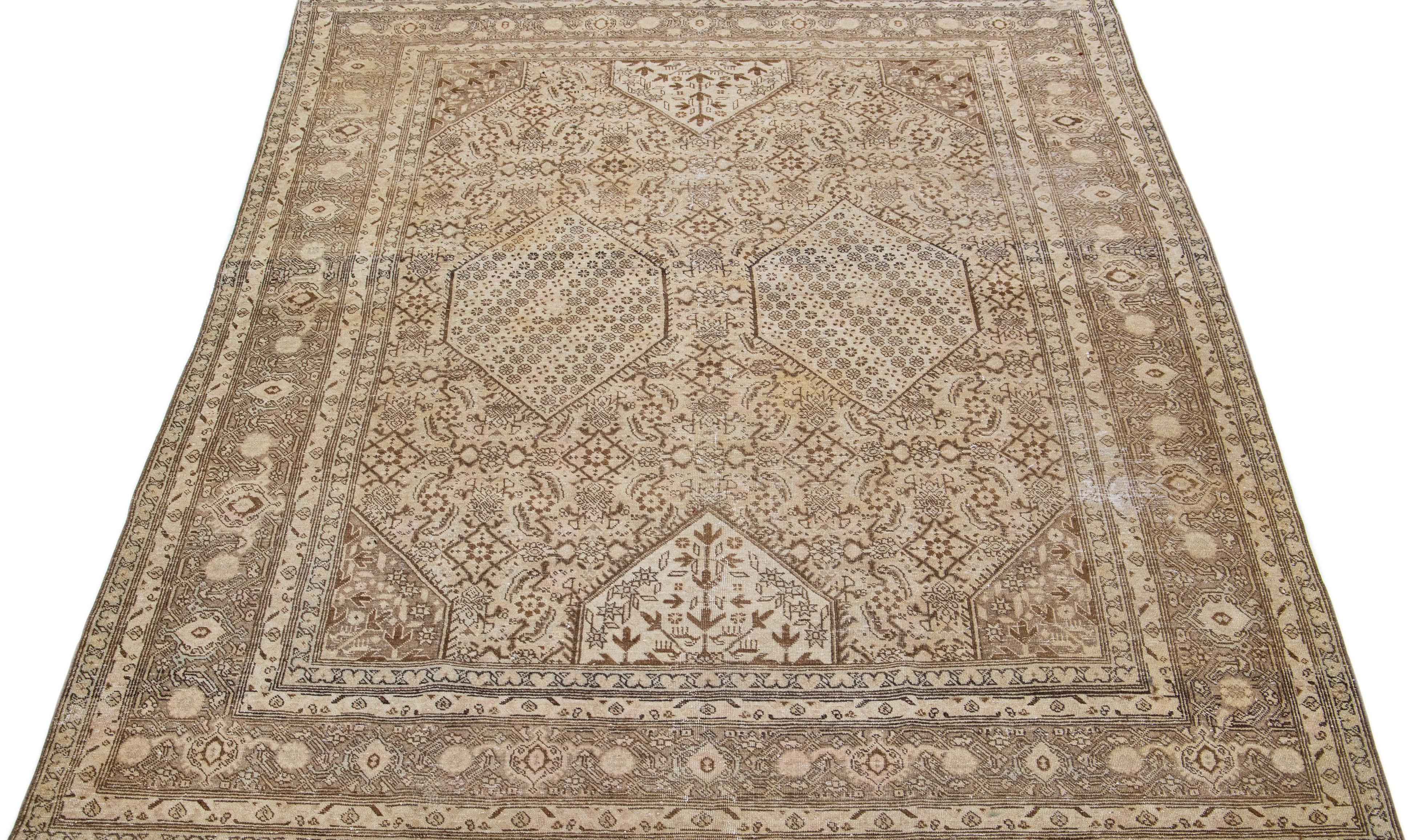 Magnifique tapis persan ancien en laine nouée à la main avec un champ de couleurs marron et beige. Cette pièce a un cadre dessiné avec des accents de pêche dans un magnifique design all-over.

Ce tapis mesure : 6'10' x 9'6