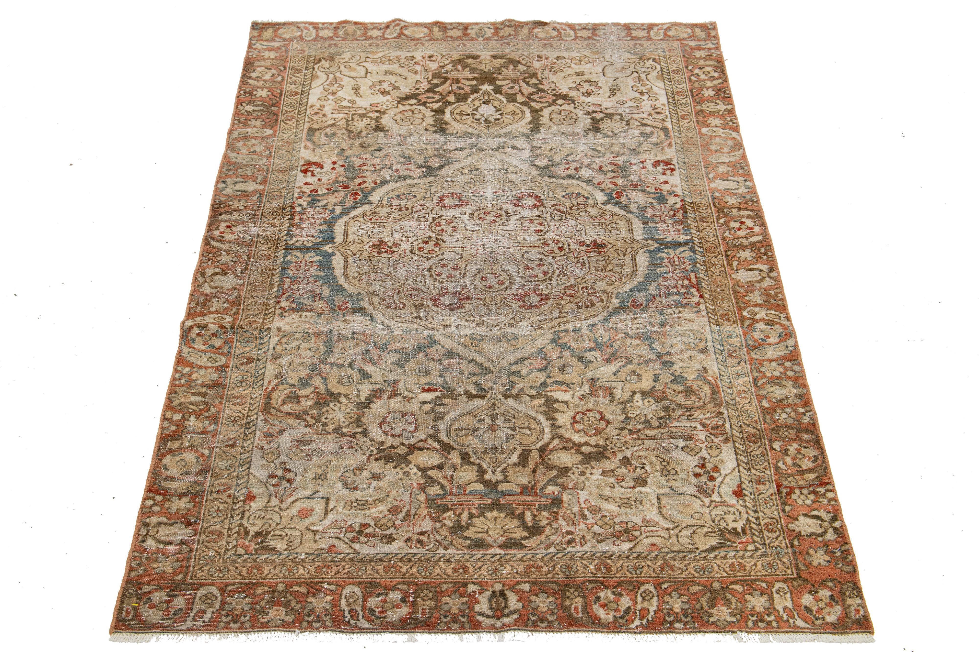 Beautiful Antique Tabriz hand-knotted wool rug with a brown color field. This Persian rug has blue, rust, and brown accents in a gorgeous medallion floral design. 

This rug measures 4'2