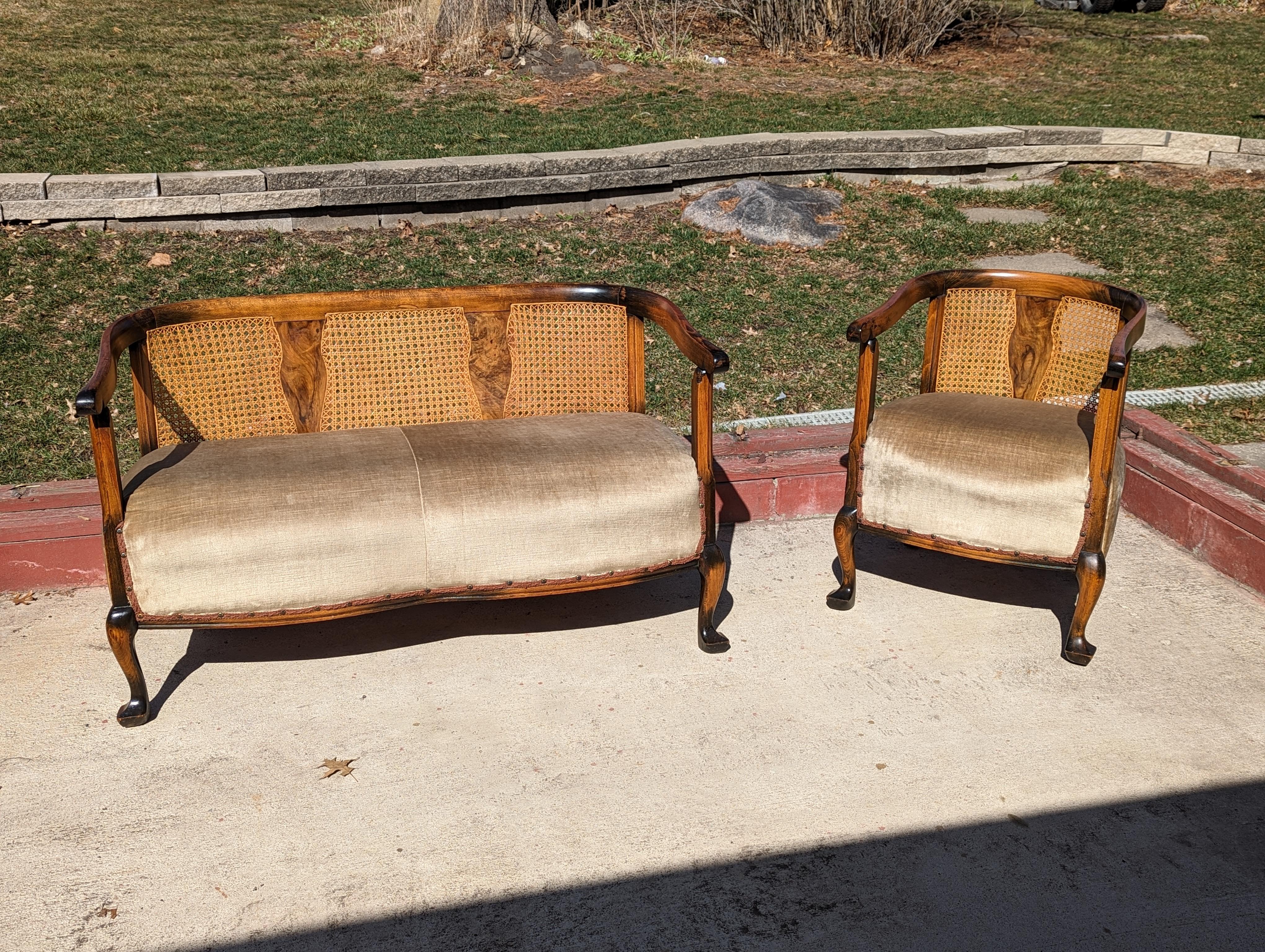Early 1900s antique settee and matching chair.

Oak and walnut construction with velvet upholstery. Nice claw style feet and scrollwork.

Beautiful highly figured walnut inlays in the center of each back. Caning is in great condition.

Settee