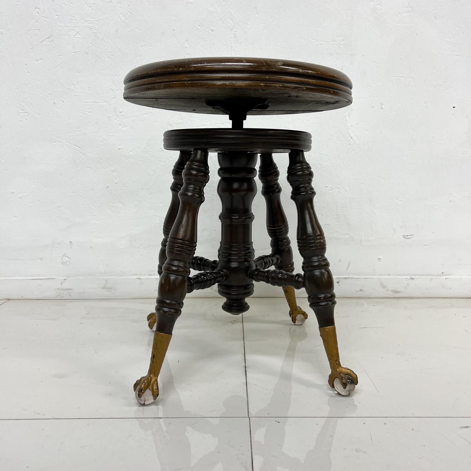 1900s antique Victorian piano stool Charles Parker 
Solid wood and brass glass eagle talon claw feet
Measures: 14.5 diameter x 19 tall 
Seat height is adjustable.
No label
Attributed to Charles Parker Co USA.
Delightful preowned antique