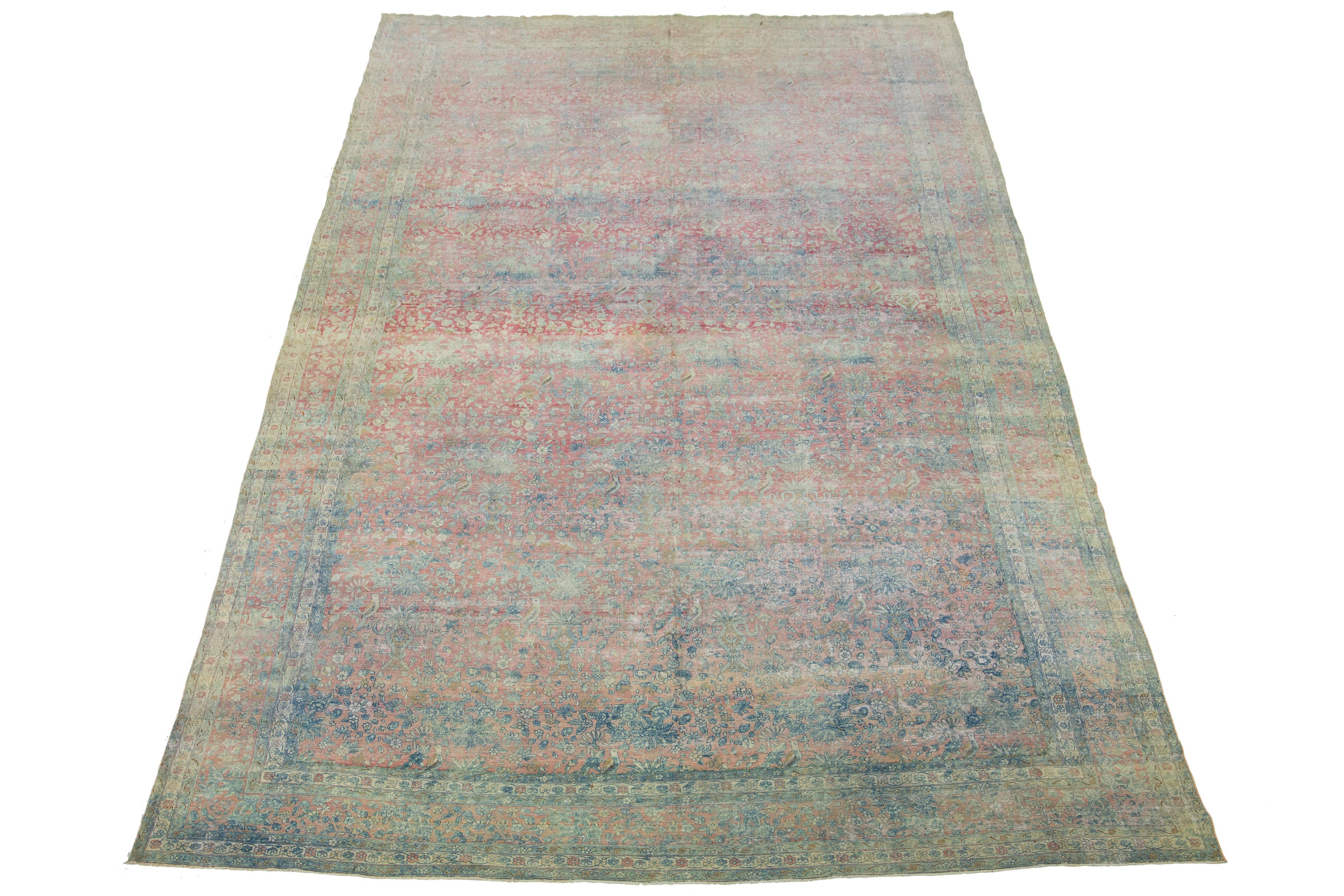 This Persian Kerman wool rug, dating back to the early 1900s, showcases a meticulously crafted allover floral design in blue. This exquisite antique rug carries a rich historical value and is ideal for those seeking elegance and sophistication in