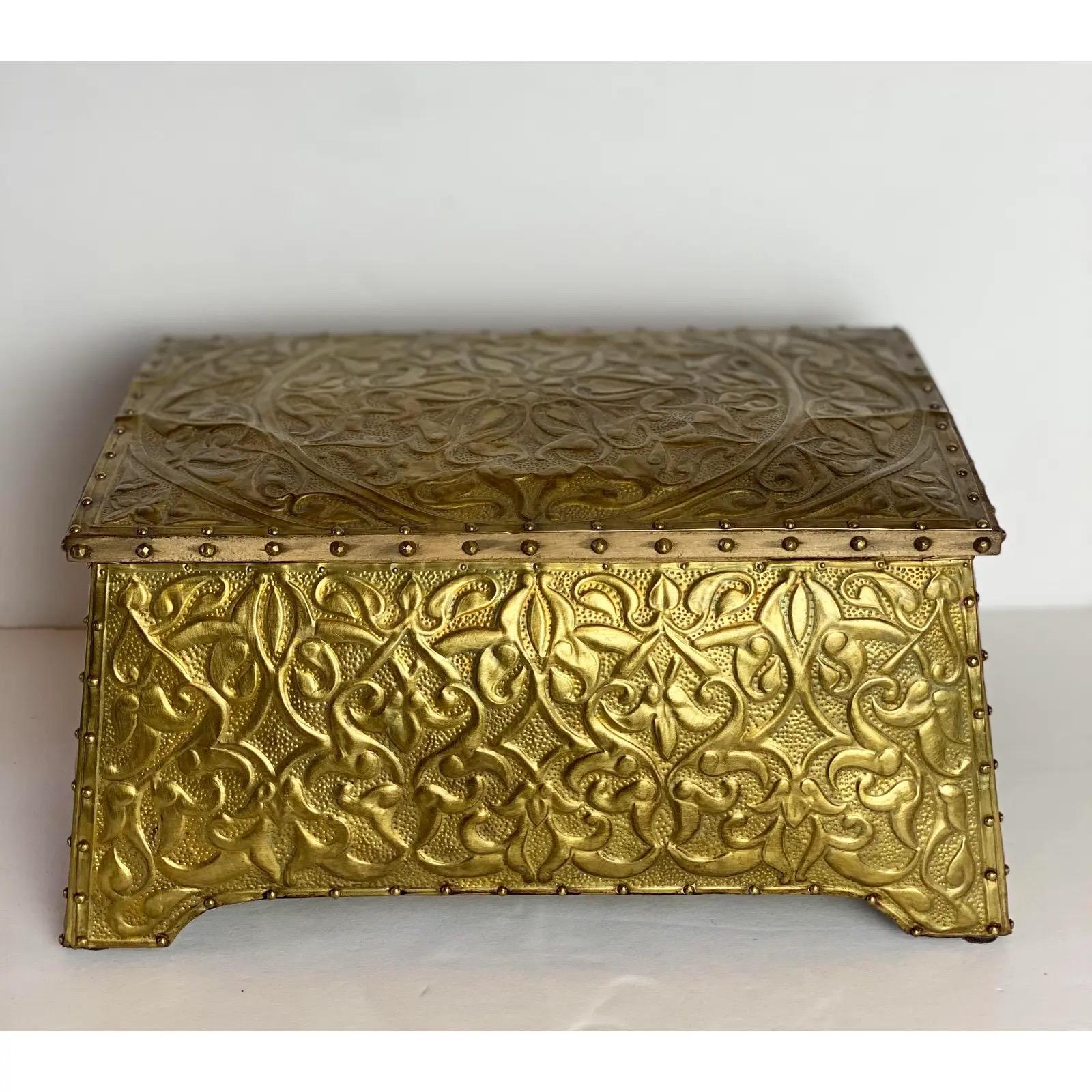 We are very pleased to offer an Old-World brass tin box from England, circa the early 1900s. This sturdy wooden box is richly covered with an embossed brass sheet nailed into place with tiny brass brads. It showcases an ornate Baroque Victorian leaf