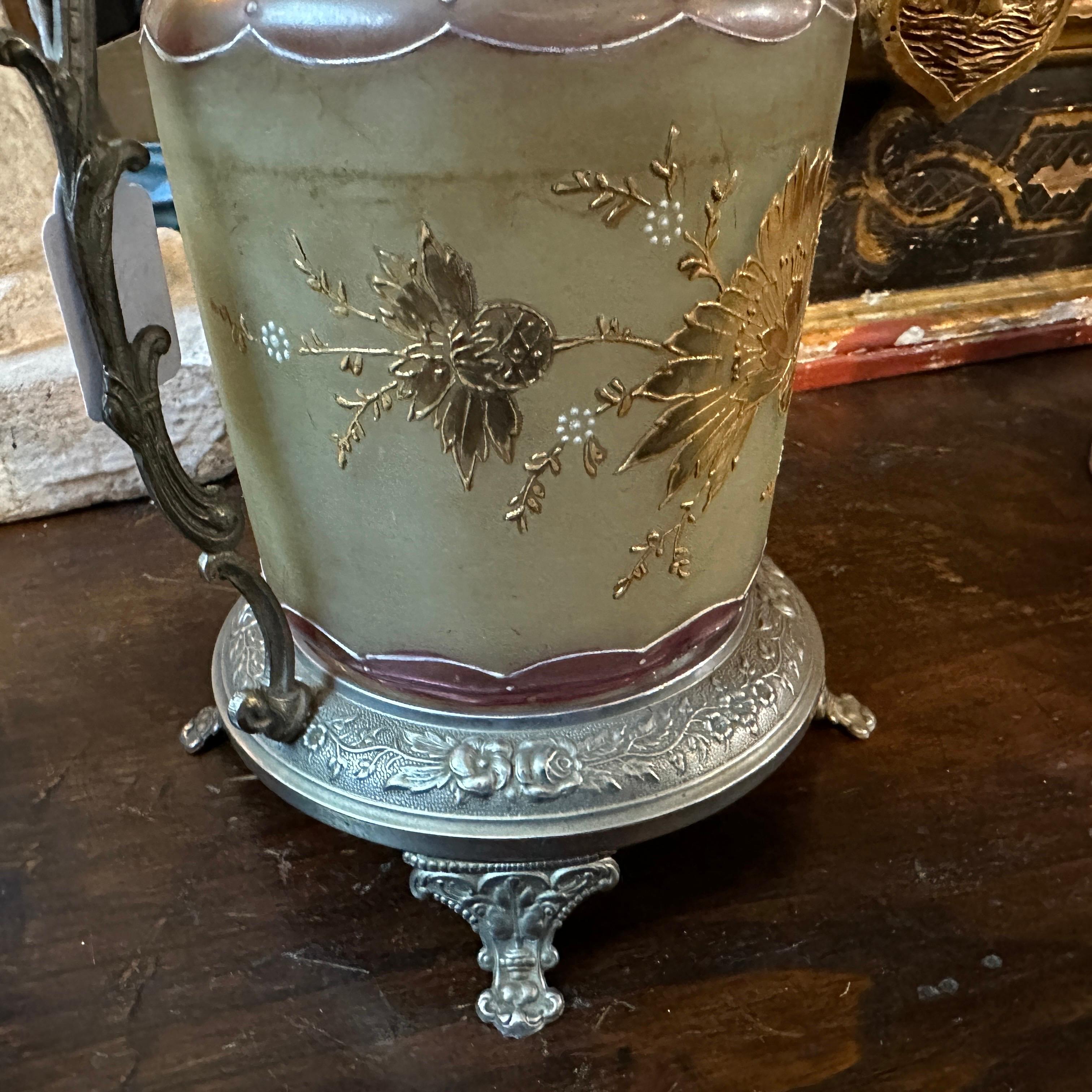 Esta caja francesa para galletas Art Nouveau es un sorprendente ejemplo de la elegancia y la artesanía características del movimiento Art Nouveau. La caja de galletas suele tener una base y un marco de metal plateado, con intrincados y fluidos
