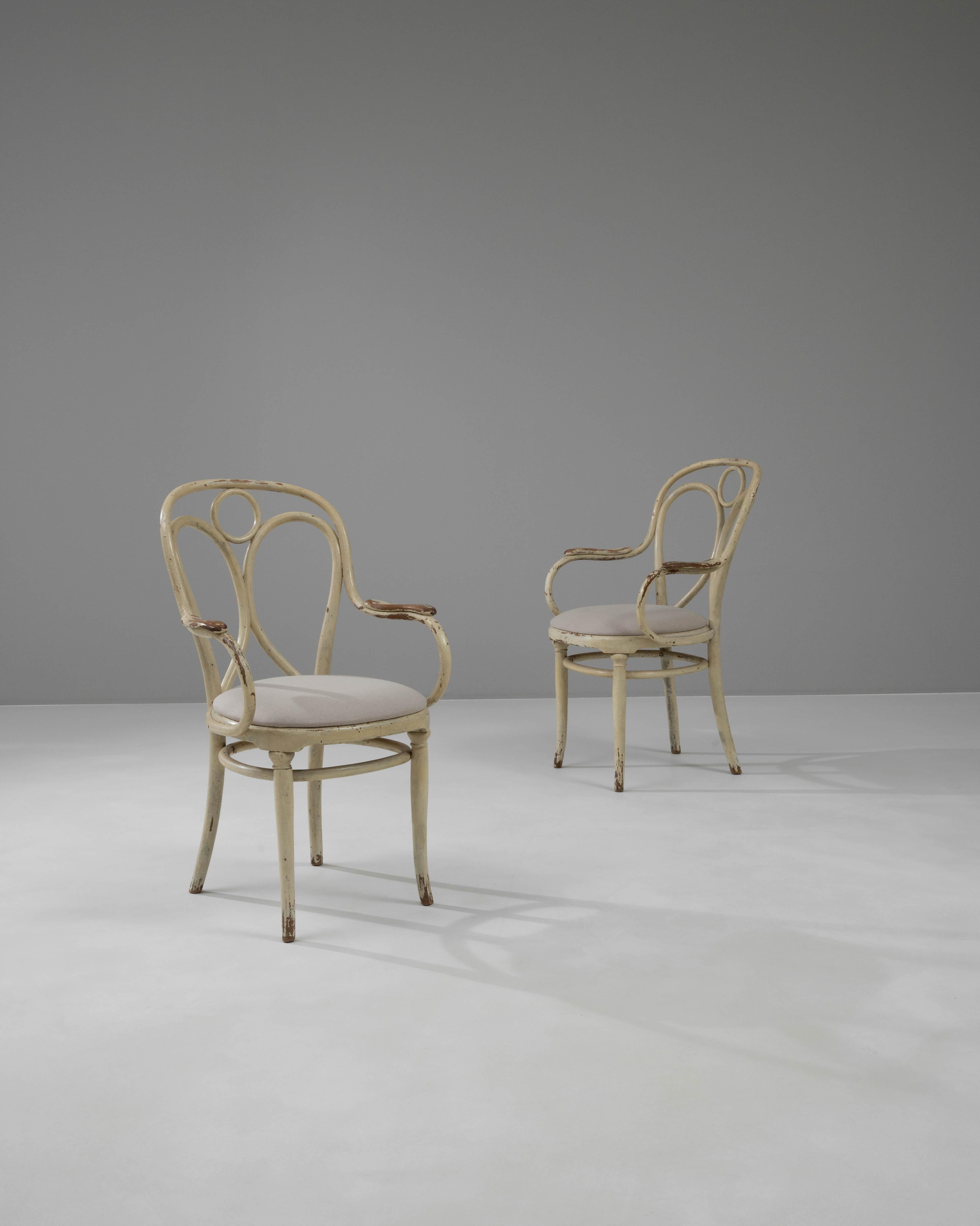 Bringen Sie ein Stück historischer Eleganz in Ihr Zuhause mit diesen österreichischen Holzstühlen aus der Zeit um 1900, ein atemberaubendes Paar, das klassische Schönheit mit kompliziertem Design verbindet. Diese Stühle sind ein Zeugnis der