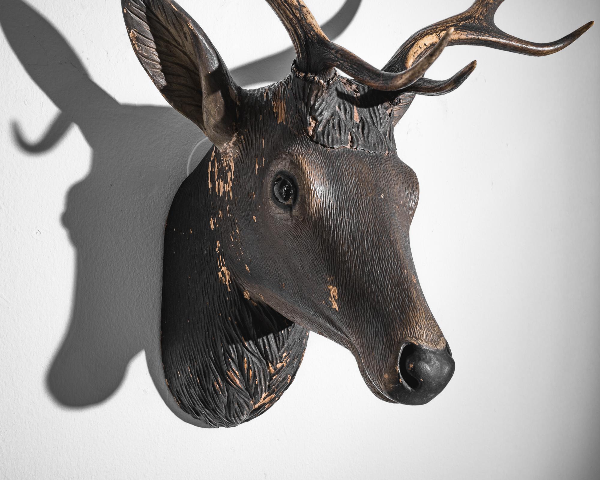 Add a touch of alpine tradition to your décor with this early 1900s Austrian wooden deer decoration. Exquisitely carved with attention to detail, this piece captures the majestic beauty of a deer with its intricate antlers and serene expression. It