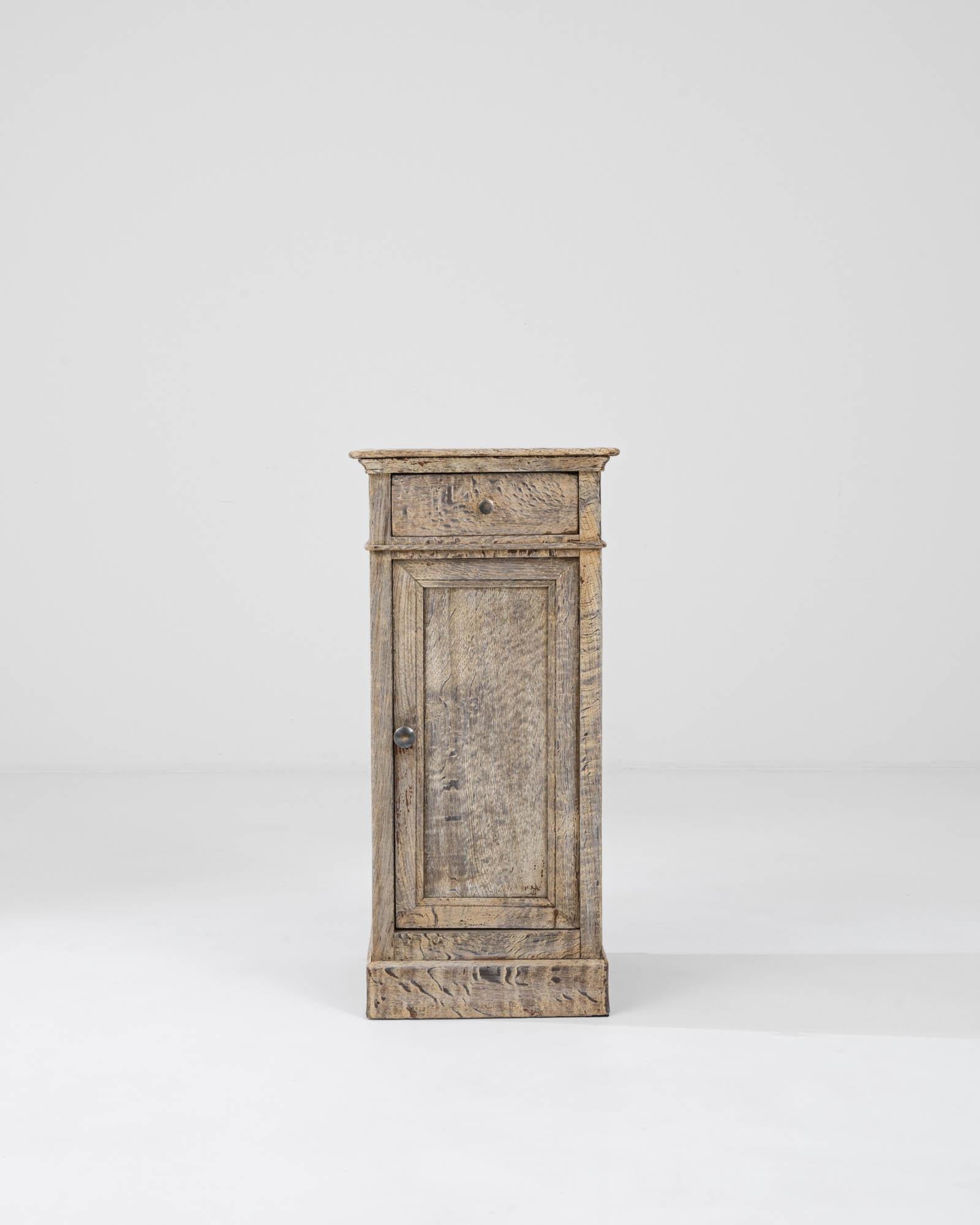 Introducing a piece of timeless elegance: our 1900s Belgian Bleached Oak Bedside Table. Crafted with meticulous attention to detail, this elongated bedside table exudes understated sophistication. Fashioned from light oak, its light finish adds a