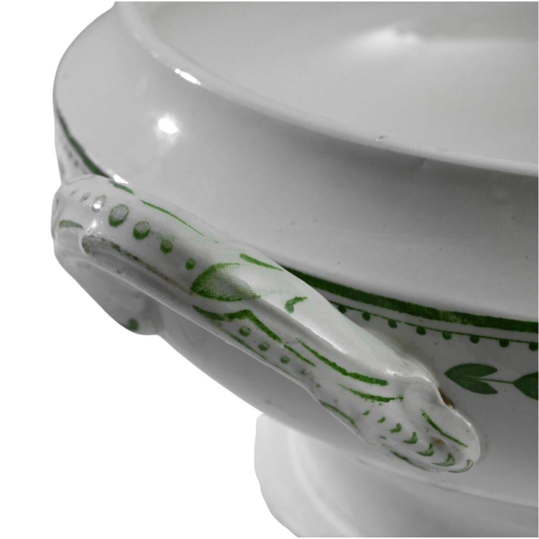 Questa zuppiera in porcellana belga del 1900 di Boch Frères La Louvière è un delizioso mix di semplicità ed eleganza. Realizzato in un'epoca in cui l'attenzione ai dettagli era fondamentale, questo pezzo presenta delicati motivi di foglie verdi che