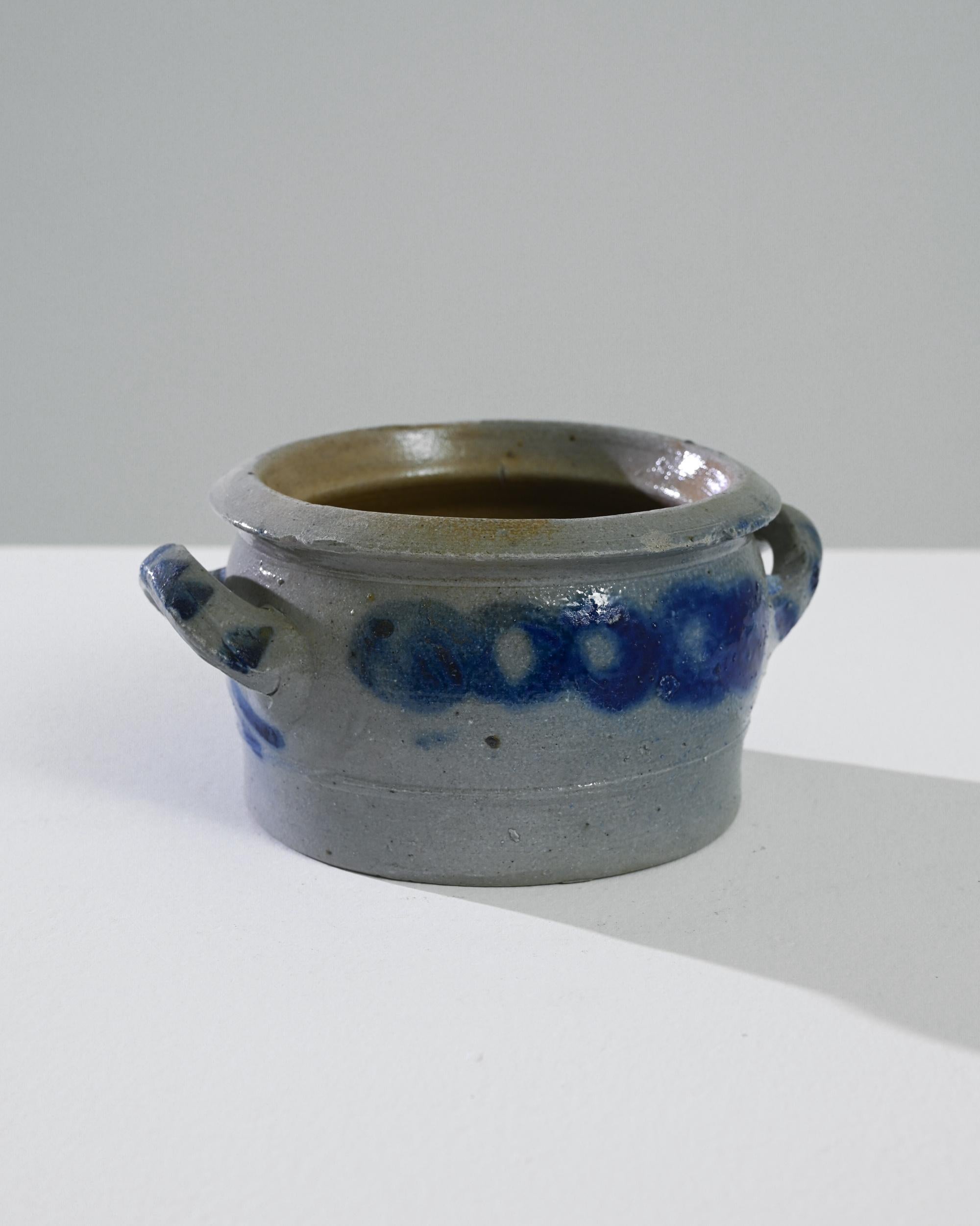 This 1900s Belgian ceramic pot is a quaint and charming piece that adds a touch of vintage European elegance to any home. Its sturdy earthenware construction and unique blue speckled glaze make it a delightful accent for your kitchen or living