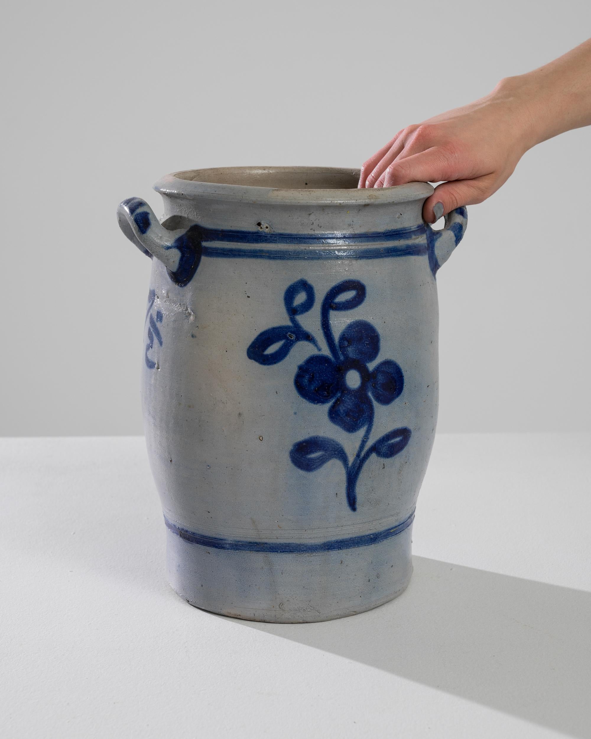 This 1900s Belgian ceramic pot is a quaint and charming piece that adds a touch of vintage European elegance to any home. Its sturdy earthenware construction and unique blue speckled glaze make it a delightful accent for your kitchen or living