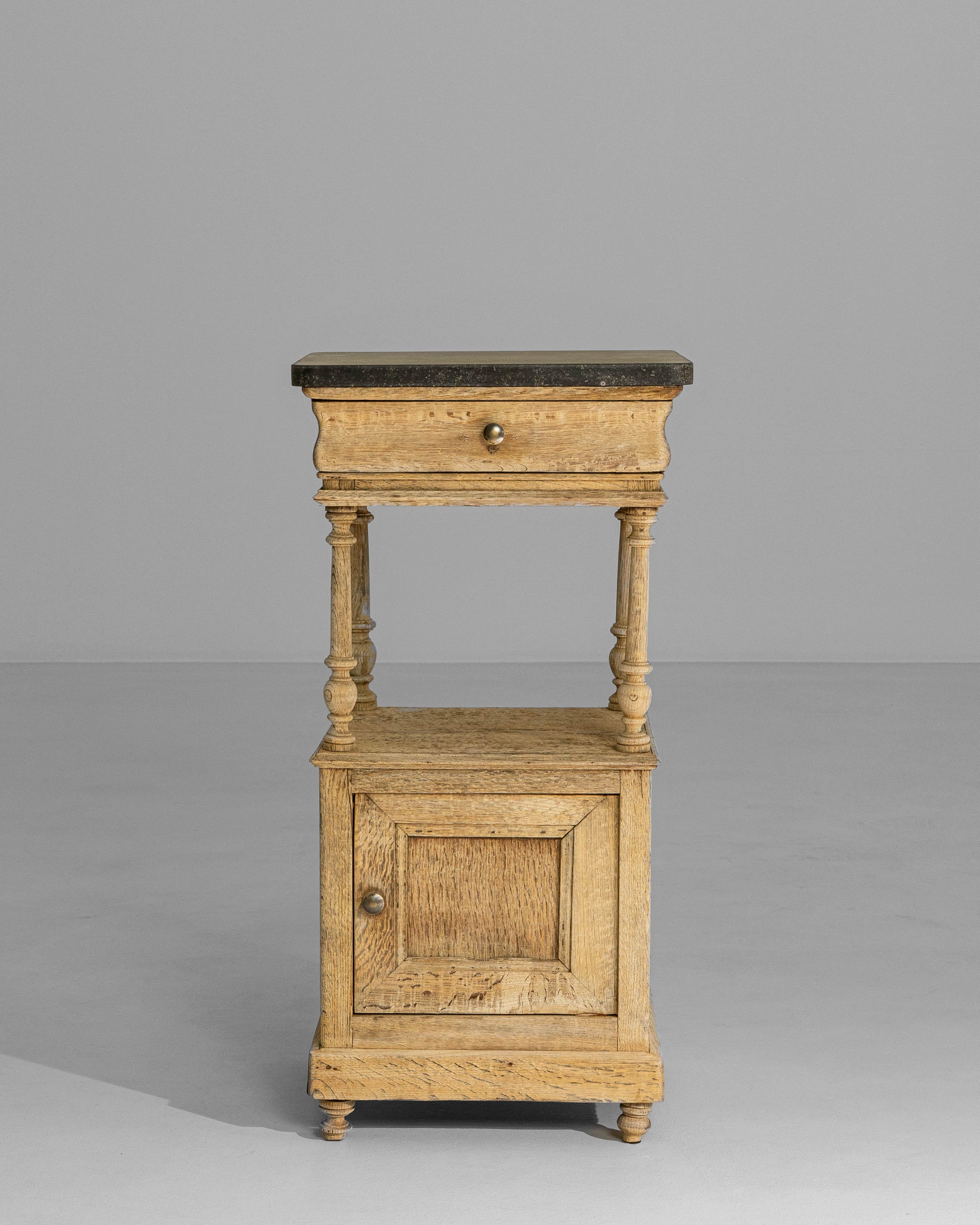 This early 1900s Belgian Louis XVI–style oak bedside table reflects the restrained elegance and balanced proportions characteristic of neoclassical design. Crafted from solid oak, the piece features clean lines softened by finely turned legs and