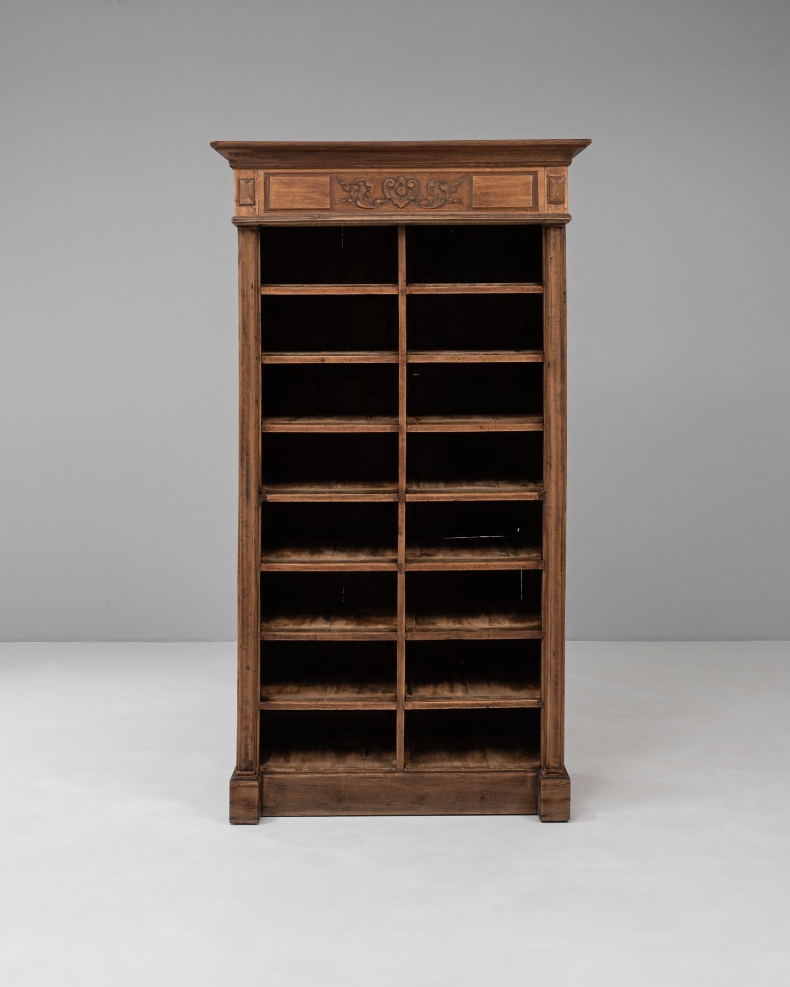 Este archivador de madera de estilo neoclásico belga de 1900 combina un diseño elegante con una finalidad utilitaria. Fabricado en madera maciza, el armario tiene una forma rectangular alta con múltiples compartimentos, originalmente pensados para