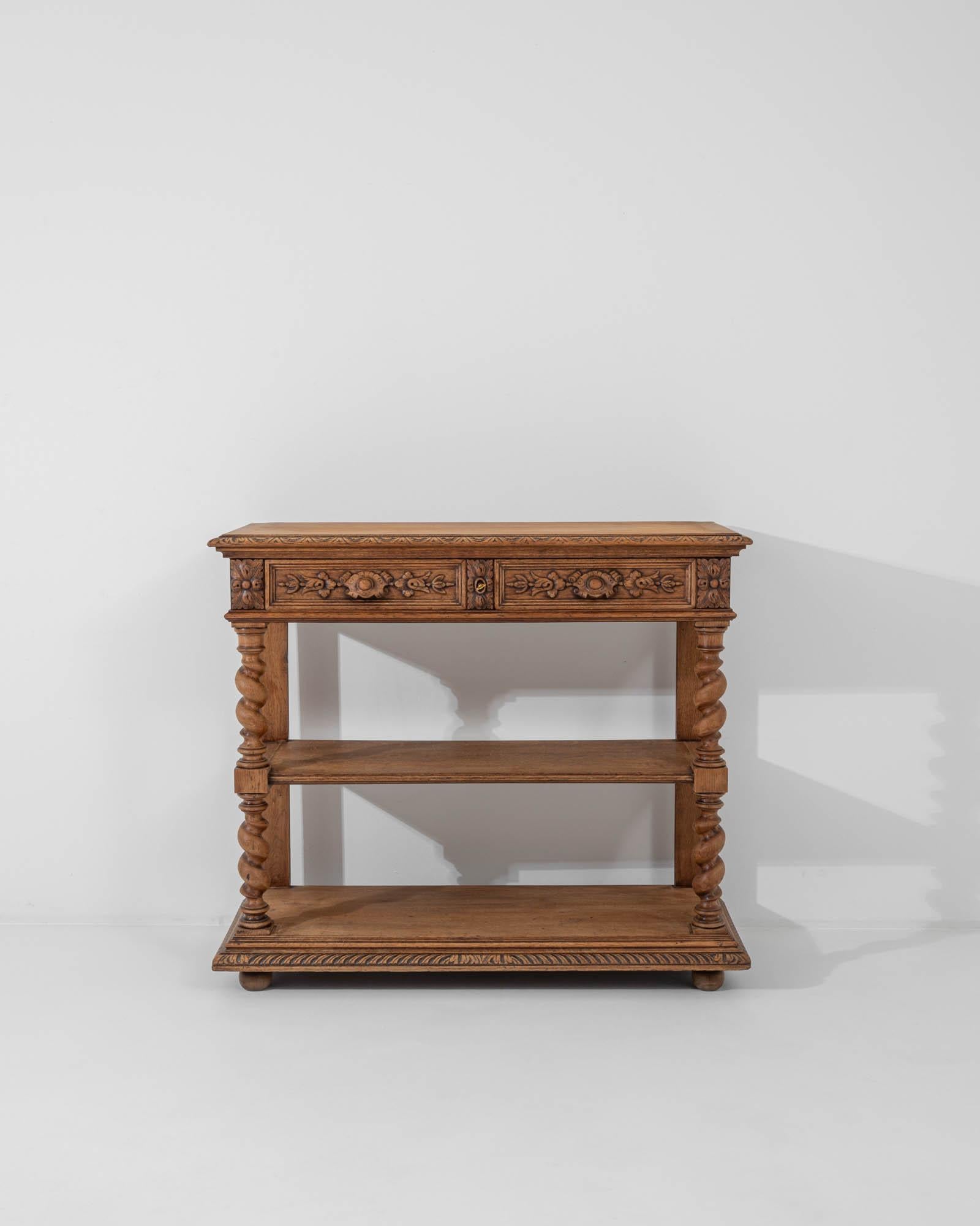 An oak console table created in Belgium, circa 1900. Exuding a bright and cheerful demeanor, this console table greets one with a dignified elegance and a flare for the ornamental. Practical as well as stylish, the table top folds open to create a