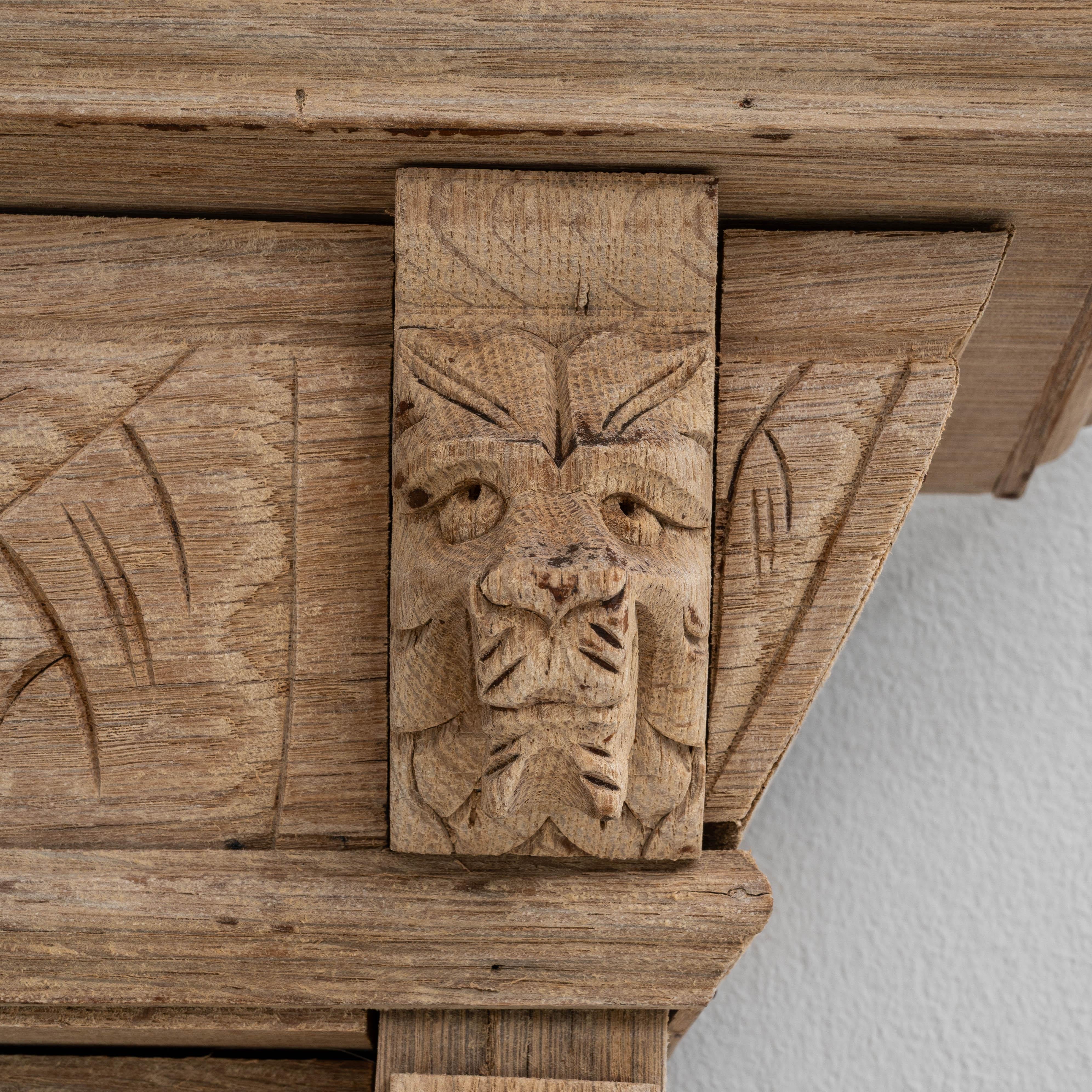 Un espejo de roble belga de 1900 que muestra la sobria elegancia y la artesanía características del diseño belga de principios de siglo. El marco está tallado en roble claro patinado de forma natural, ofreciendo un cálido tono orgánico que resalta