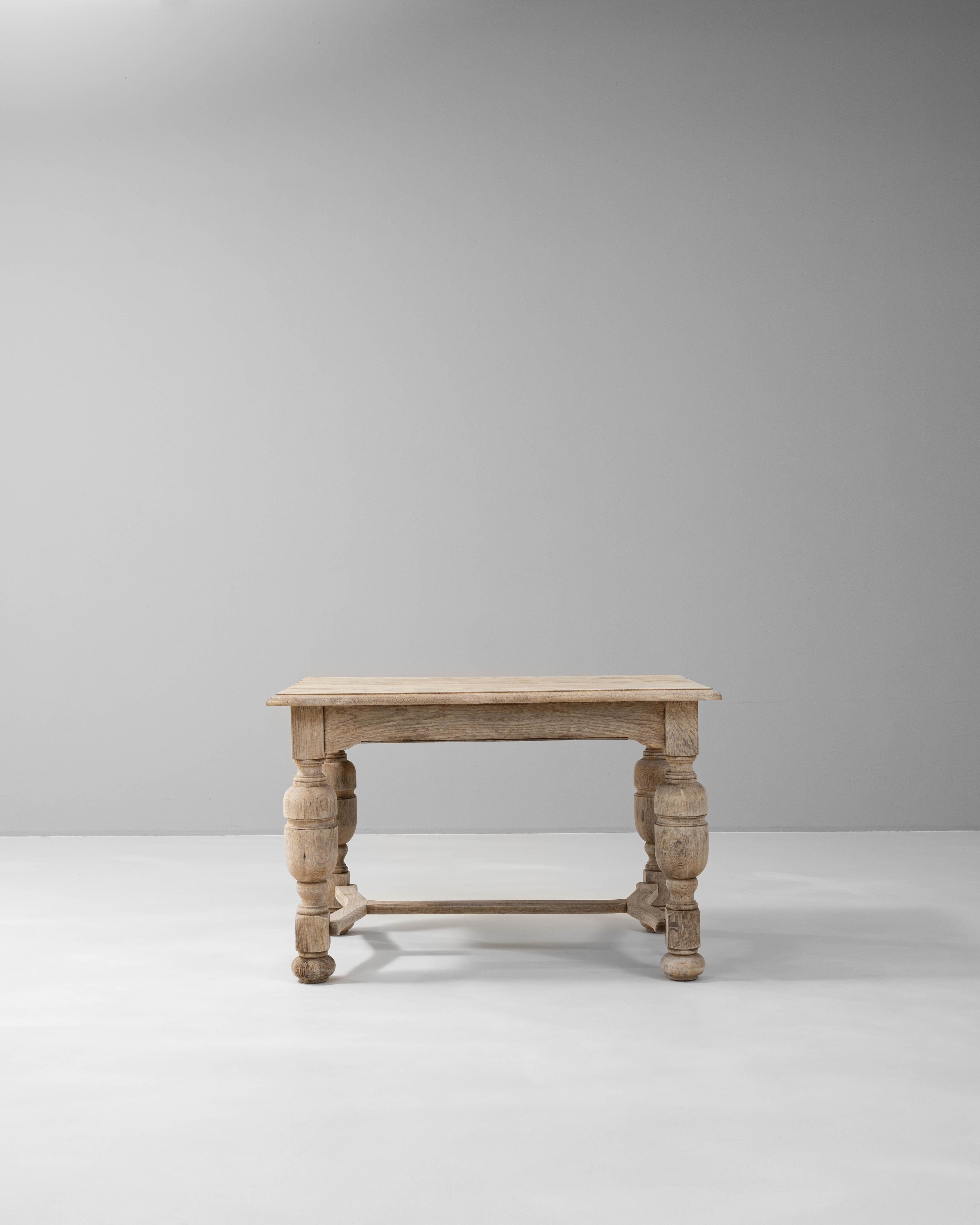 This beautiful 1900s Belgian oak side table captures the charm of vintage European craftsmanship, perfect for adding character to any room. Constructed from solid oak, it features intricately turned legs and a sturdy cross-stretcher, which not only