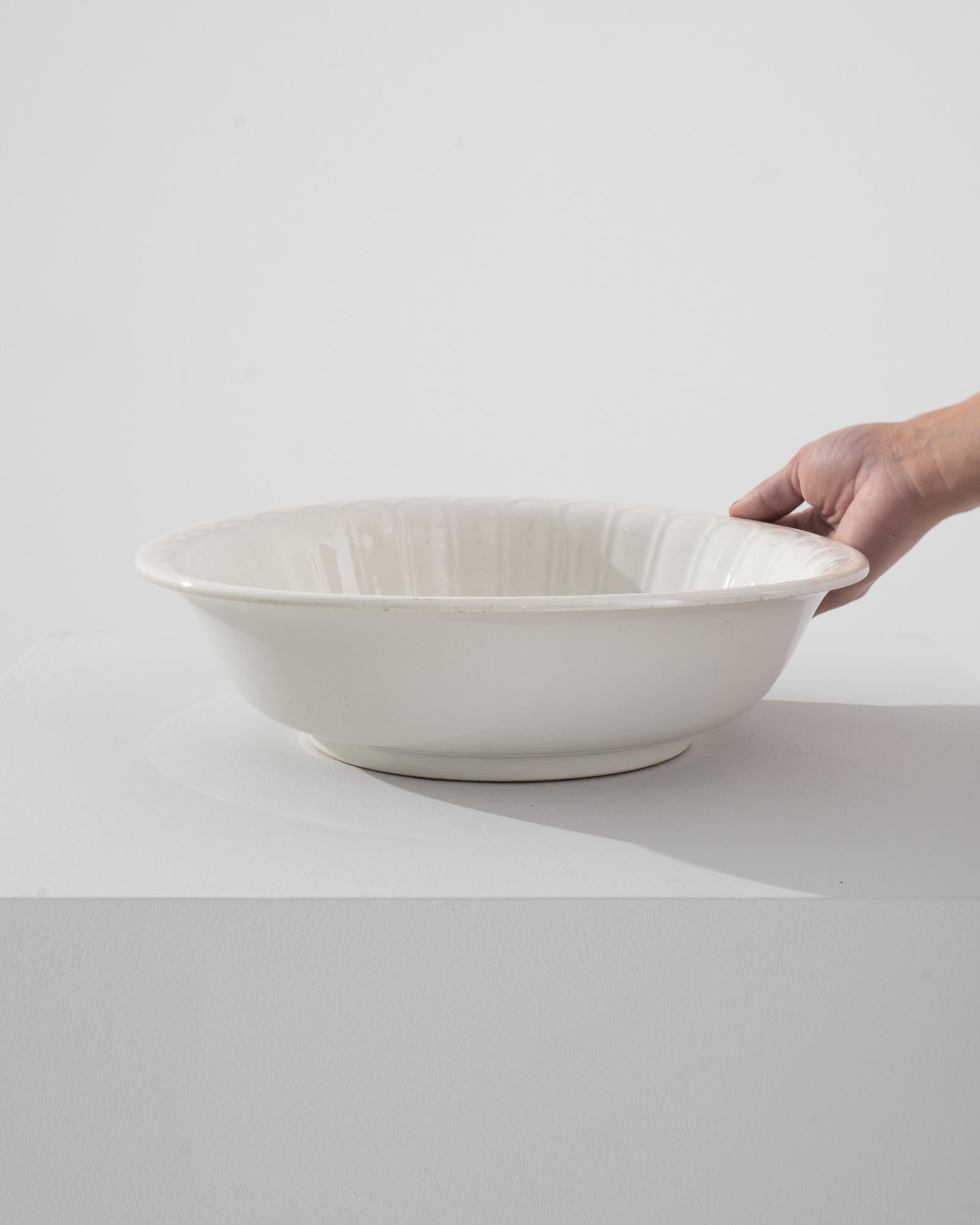 Embrace the understated elegance of the early 20th century with this 1900s Belgian Porcelain Salad Bowl. Crafted during a time of exquisite attention to detail, this porcelain piece exudes timeless grace with its classic white hue and delicate