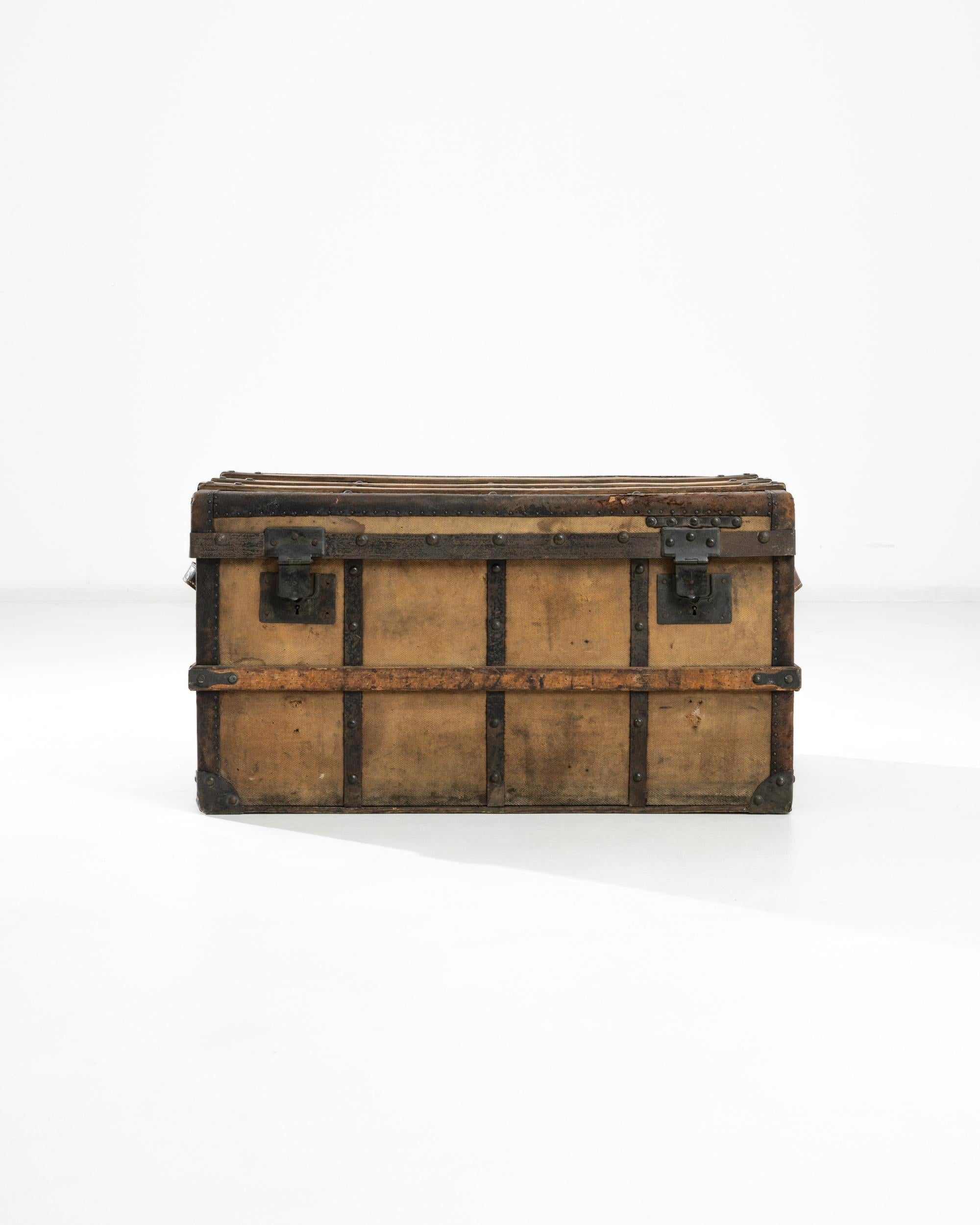 A Belgian wooden chest from the twentieth century. Created by J. Devaux Aine, a luggage fabricator in Brussels, this trunk offers function while radiating character. Its leather, fabric, metal and wood each communicate its age in a subtle patina.