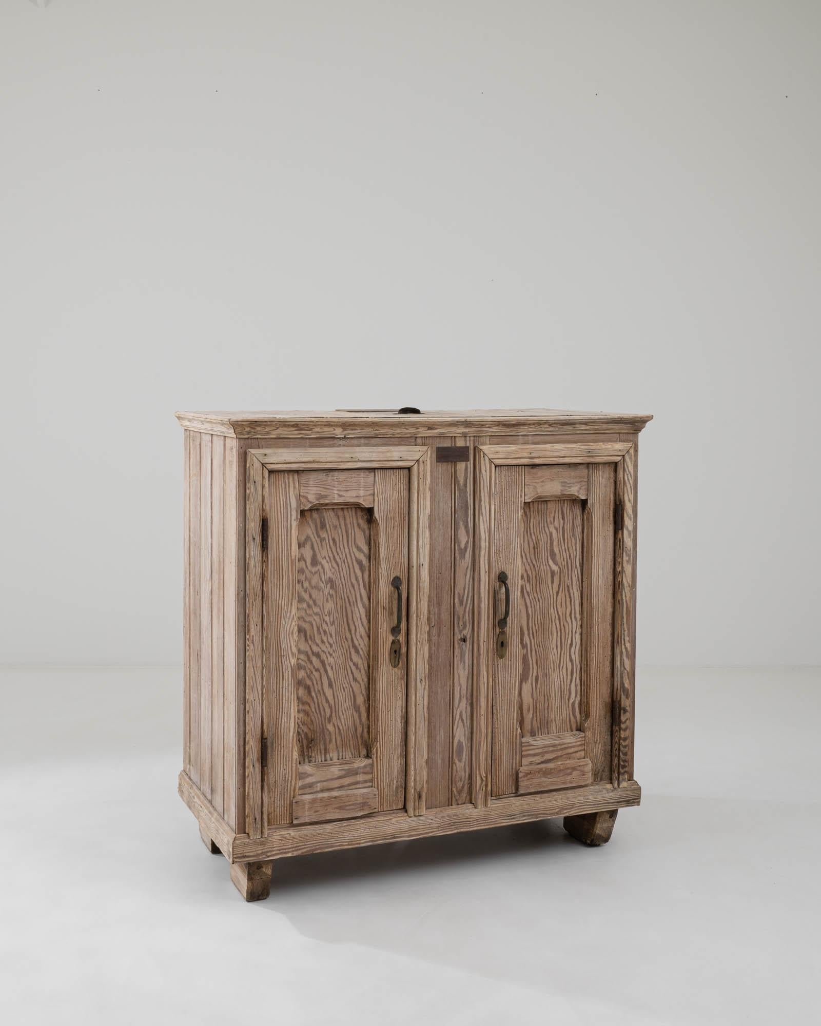 A wooden ice chestcreated in 1900s Belgium. This intriguing piece exudes a timeless air despite its antiquated use. Serving a unique function, this antiquated refridgerator would have stored ice, along with other perishibles, specially insulated to