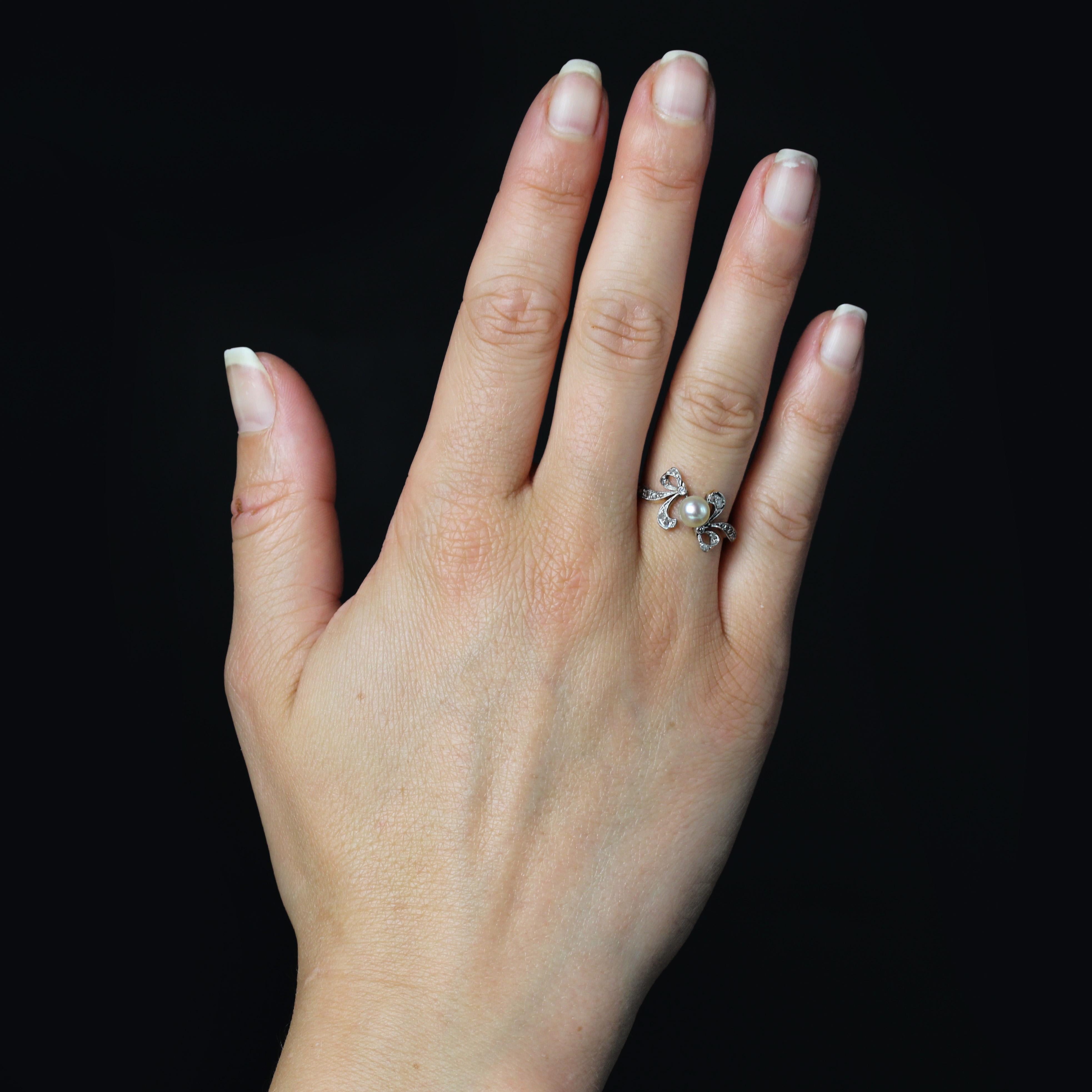 Anello in oro giallo 18 carati e platino.
Autentico anello antico, montatura asimmetrica con 2 motivi a nastro annodati sul davanti e che si estendono fino all'inizio della fascia. Ogni motivo è ornato da un diamante taglio rosa in platino e
