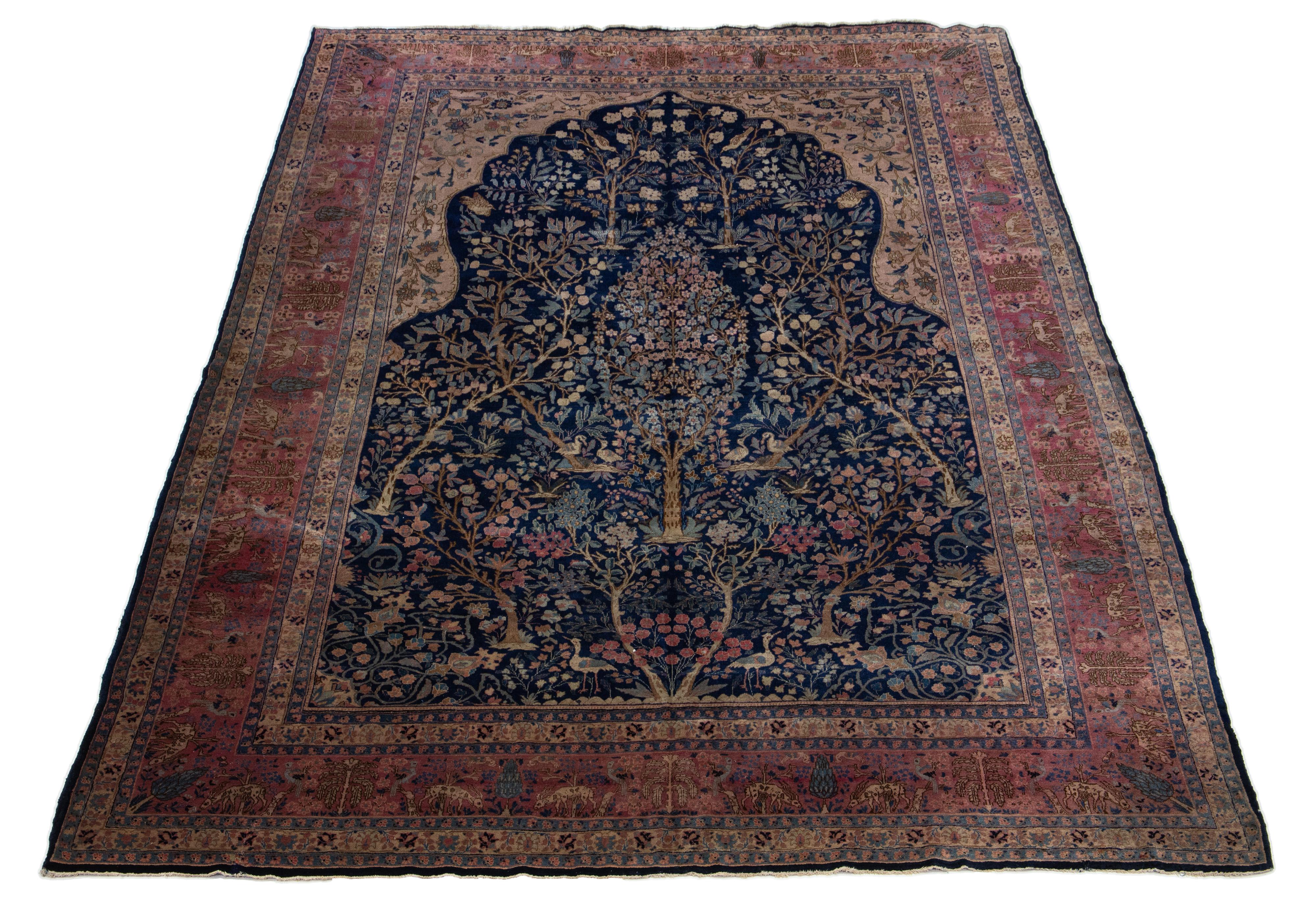 Dieser persische Wollteppich aus Täbris ist handgefertigt und zeigt ein klassisches florales Muster. Der marineblaue Hintergrund kontrastiert das Design, das sich in Lila-, Hellblau- und Brauntönen präsentiert.

Dieser Teppich misst  9'3