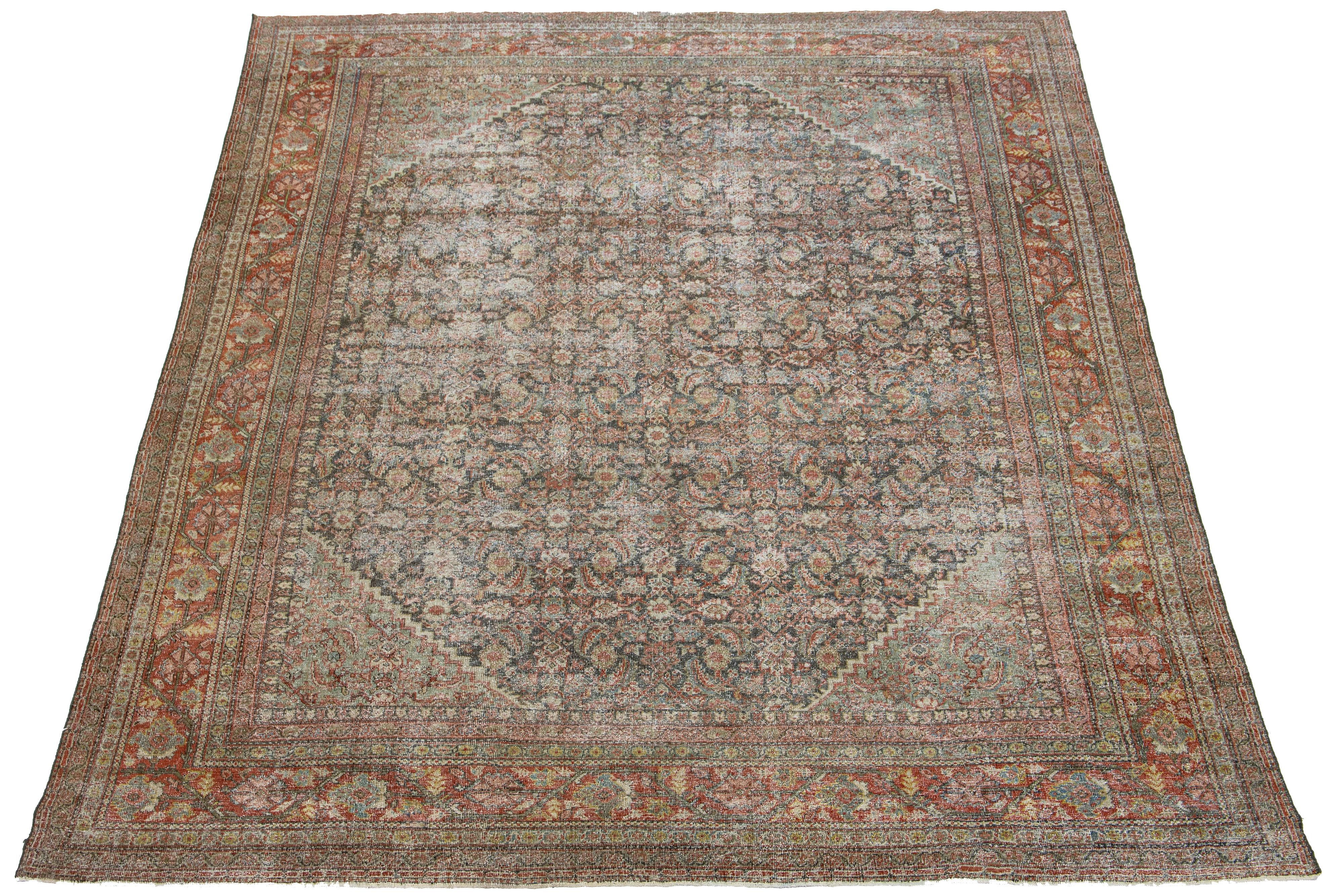 Beautiful antique hand-knotted Mahal wool rug with a blue field. It features terracotta, red, and yellow accents in an all-over floral design.

This rug measures 10'3