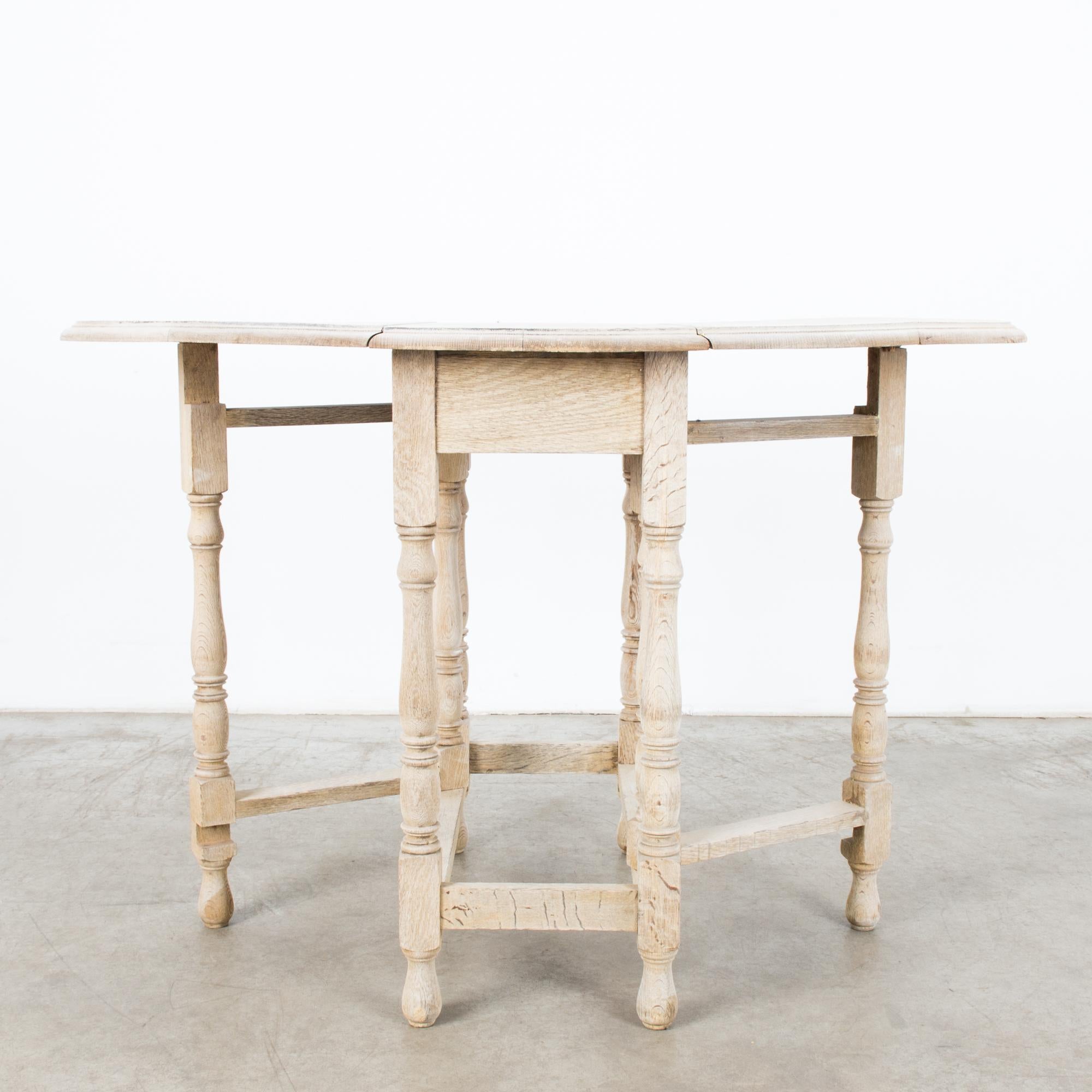 A bleached oak gate leg table from the United Kingdom, circa 1900. Developed in England in the sixteenth century, the gate leg table was an early marvel of space saving innovation. This piece in beautifully grained oak shows how the style was