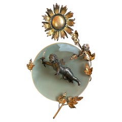 Cherubino in bronzo su piatto in ceramica del 1900 e decorazione floreale in metallo dorato a raggiera, Belgio