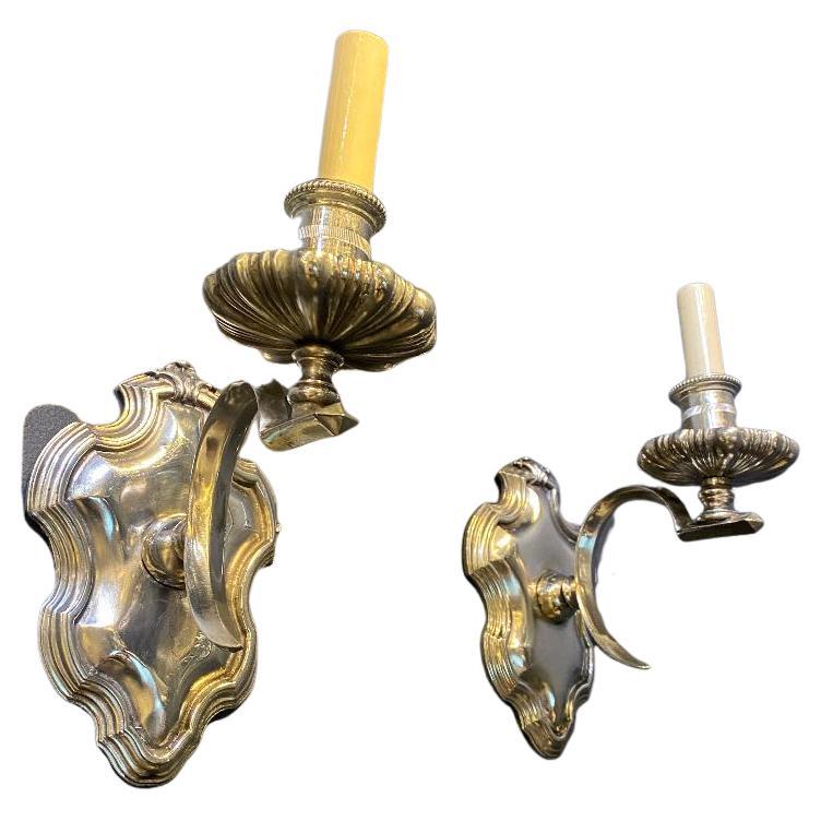 A pair of circa 1900 Caldwell one light sconces with unusual arm design.