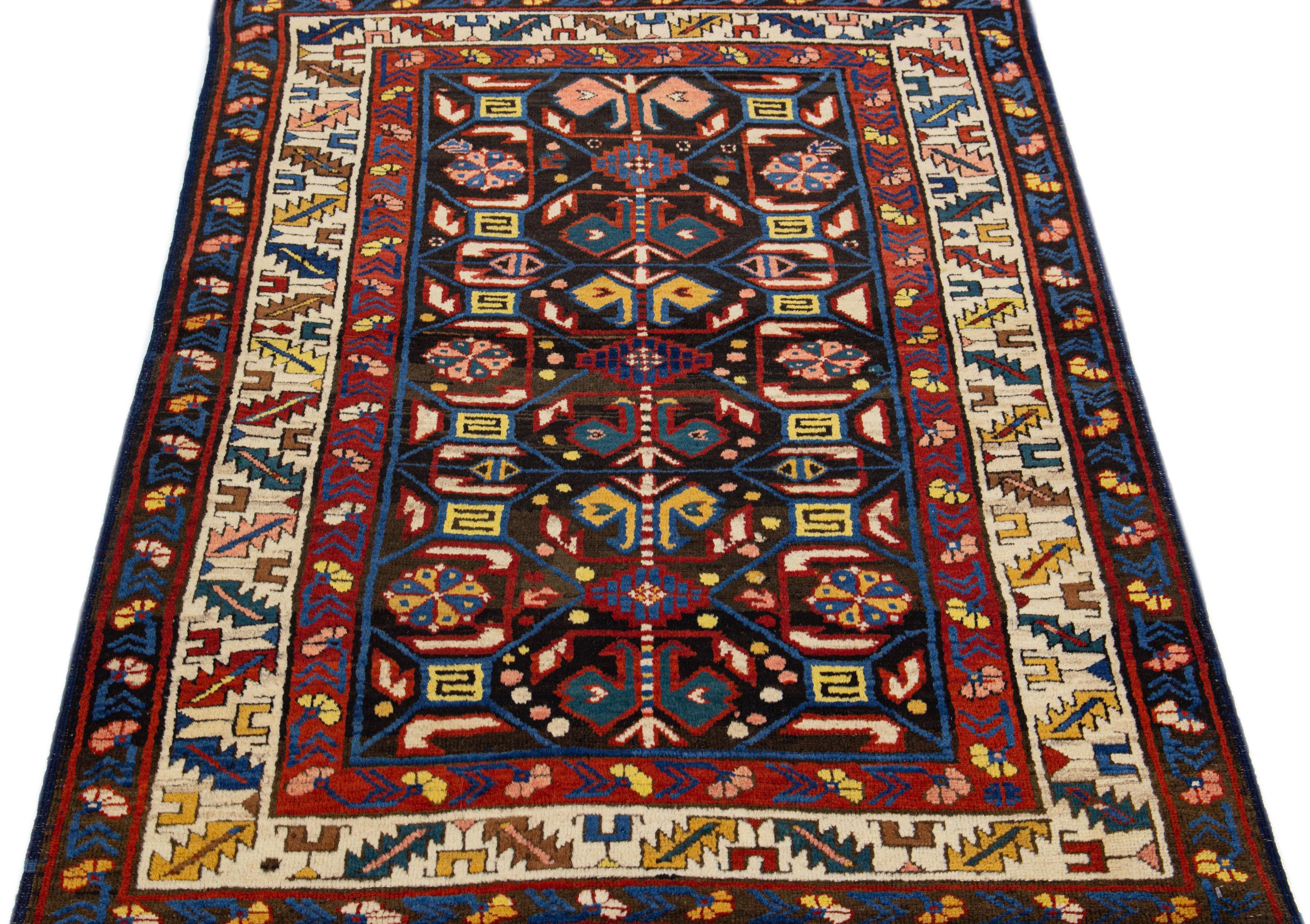 1900s Kazak wool rug, meticulously crafted by hand. The rug boasts a rich brown color palette, adorned with delicate embellishments in varying shades of yellow, peach, blue, and beige, showcasing an intricate geometric pattern that covers the