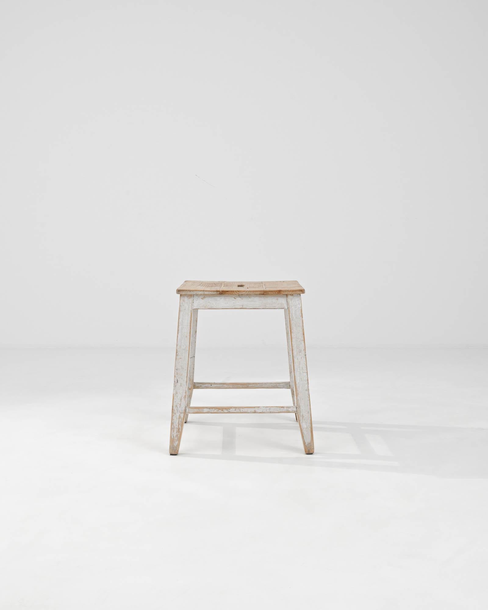 Introducing our enchanting 1900s Central European Wooden Stool, a delightful vintage accent with timeless appeal. Crafted with care, this simple yet charming wood stool exudes rustic elegance. Its splayed legs, joined by square stretchers and