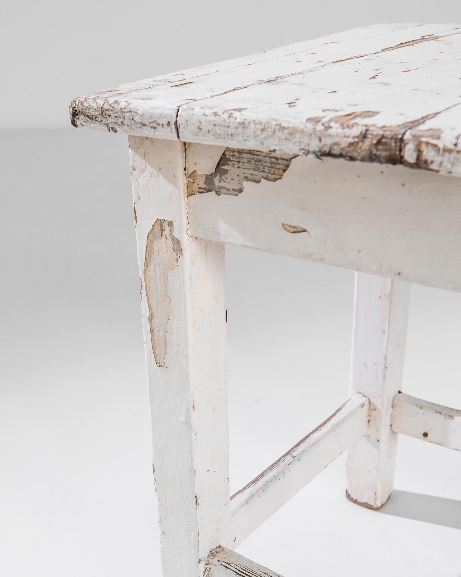 Step back in time with this charming 1900s Central European Wooden Stool, a piece that exudes rustic elegance and simplicity. Its white patinated finish tells a story of years gone by, each scuff and scratch a testament to its history. Designed with