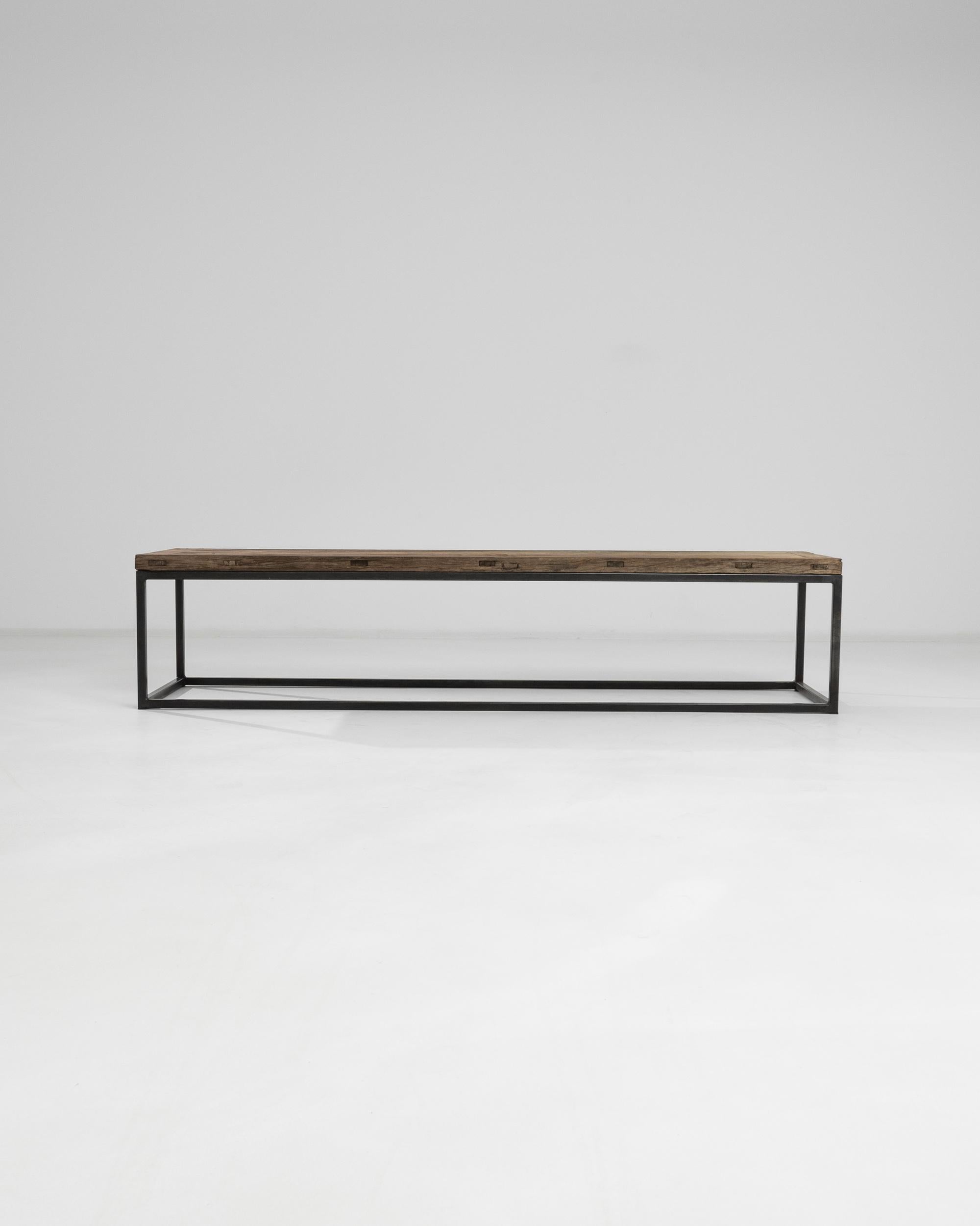 Echoing minimalist tendencies of Western mid-century furniture, this coffee tabletop was crafted in China circa 1900. The sleek rectangular base made out of blackened iron elevates the raw wooden top with few marks of time. Metal and wood, two