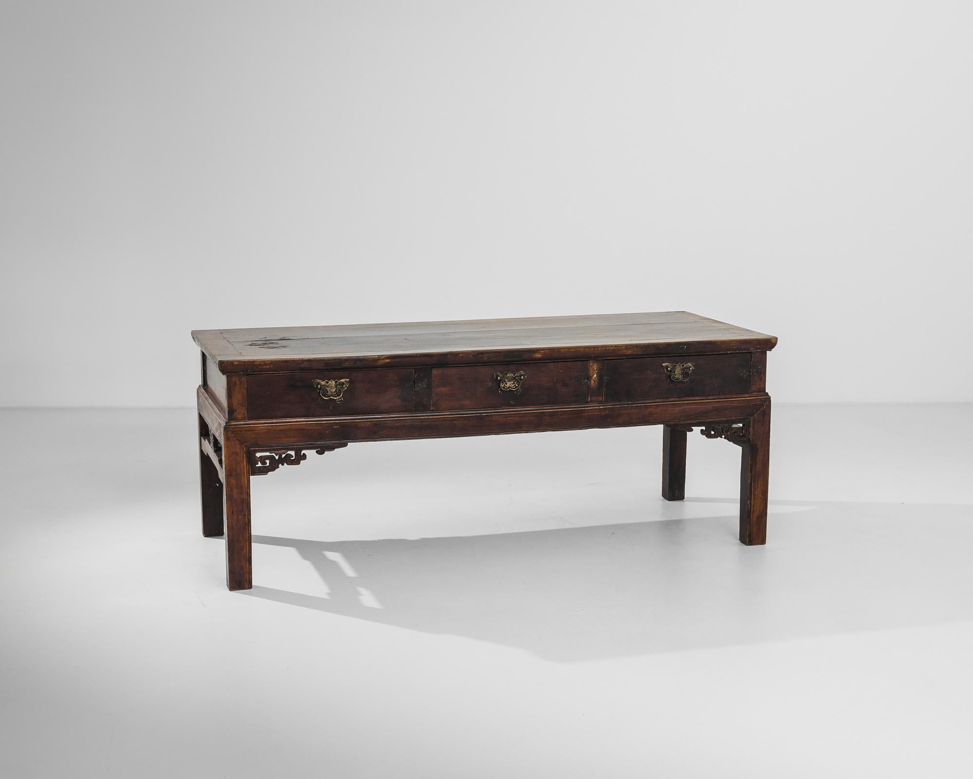 An occasional table from China, produced circa 1900. A charming antique table that updates ancient techniques and styles for the twentieth century. From details such as the meander patterns serving a flamboyant buttress, to the bumblebee-moth
