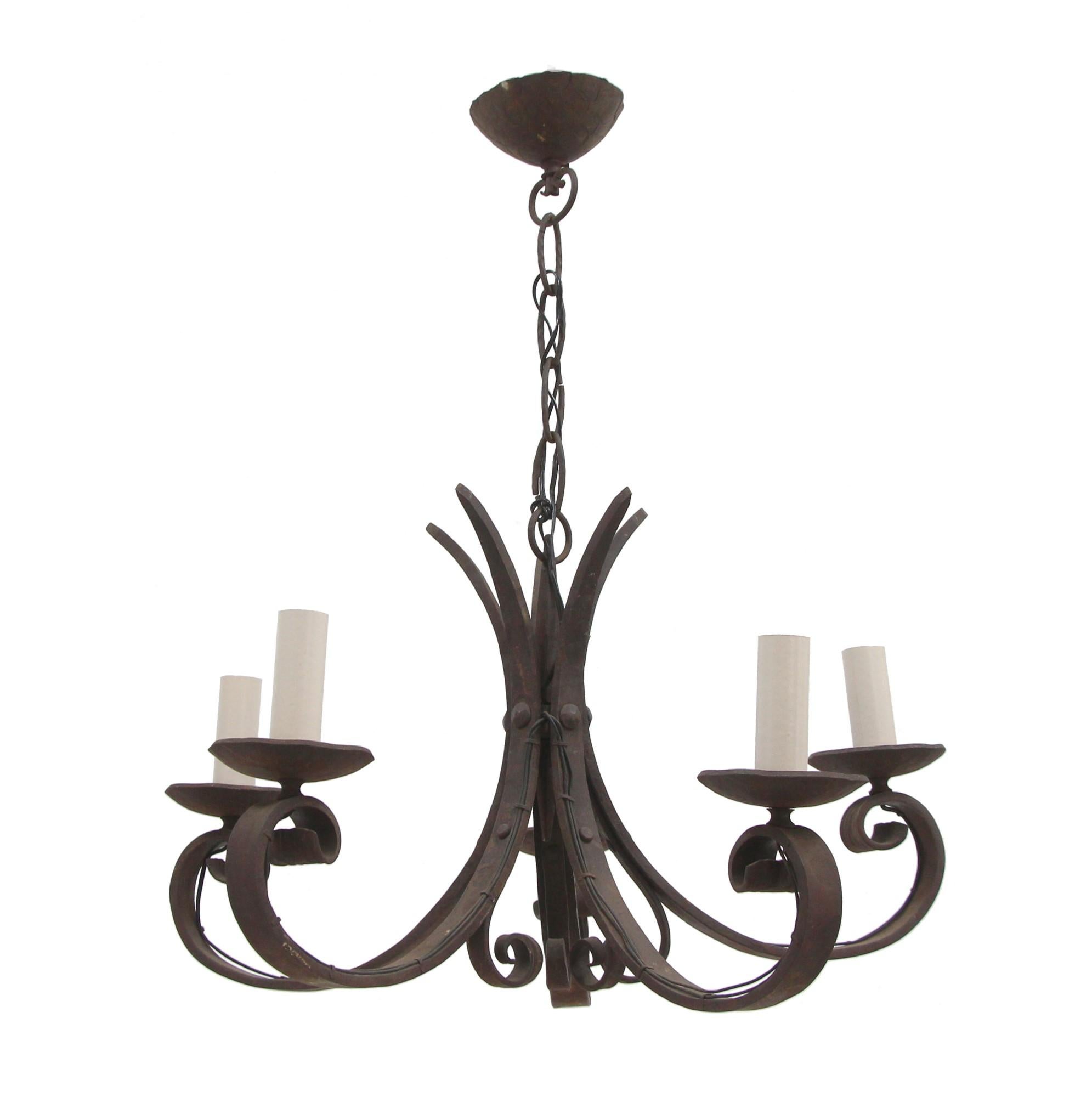 This antique wrought iron chandelier has hand-forged detail and is original to the mid 1900s. It has a country look and is graced with five looped arms. Price includes restoration and rewiring. This can be seen at our 400 Gilligan St location in