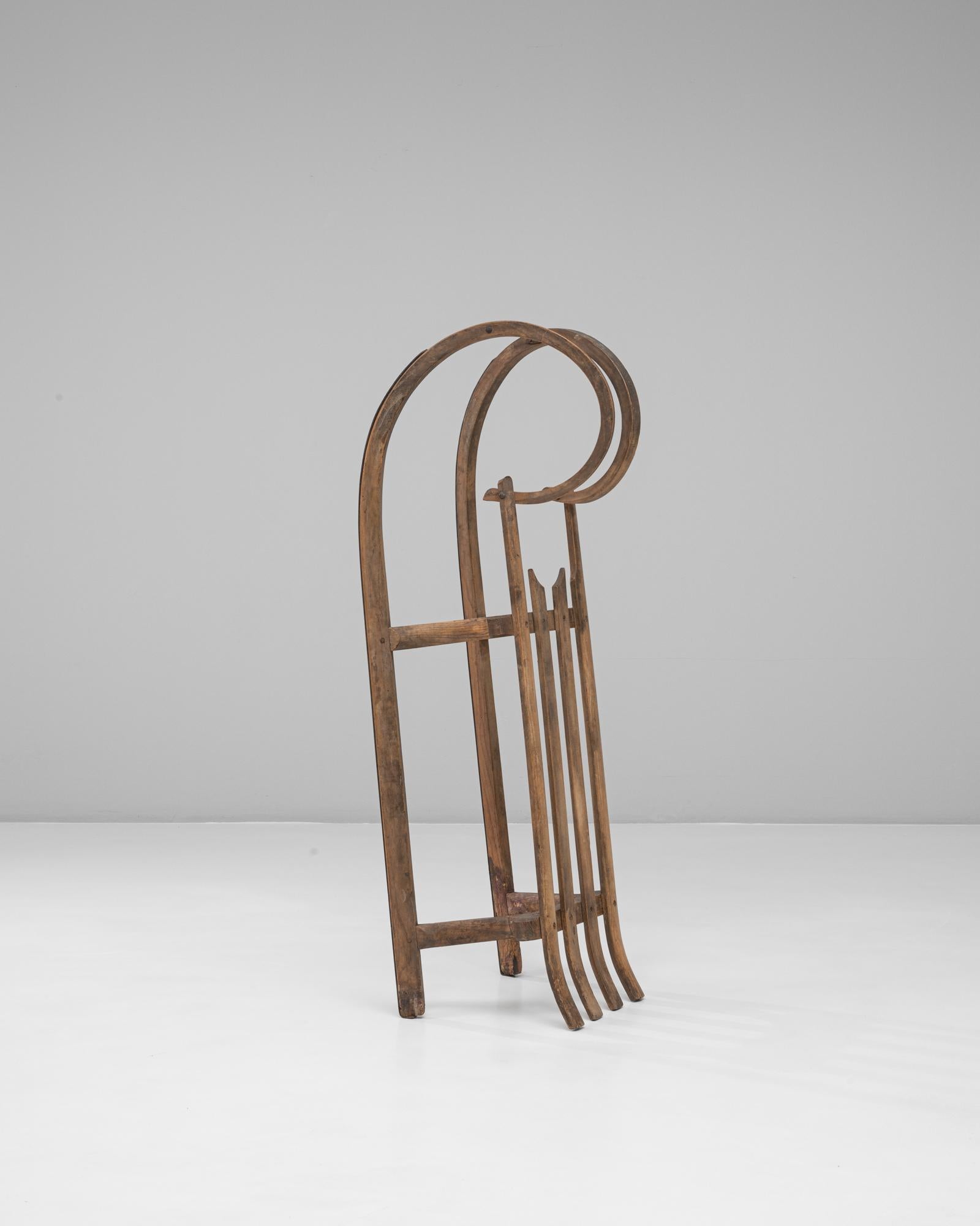 Cette luge tchèque en bois courbé des années 1900 illustre l'artisanat du début du XXe siècle avec son cadre élégamment incurvé et sa construction en bois robuste. Le design se caractérise par des patins gracieusement bouclés et une assise à lattes,