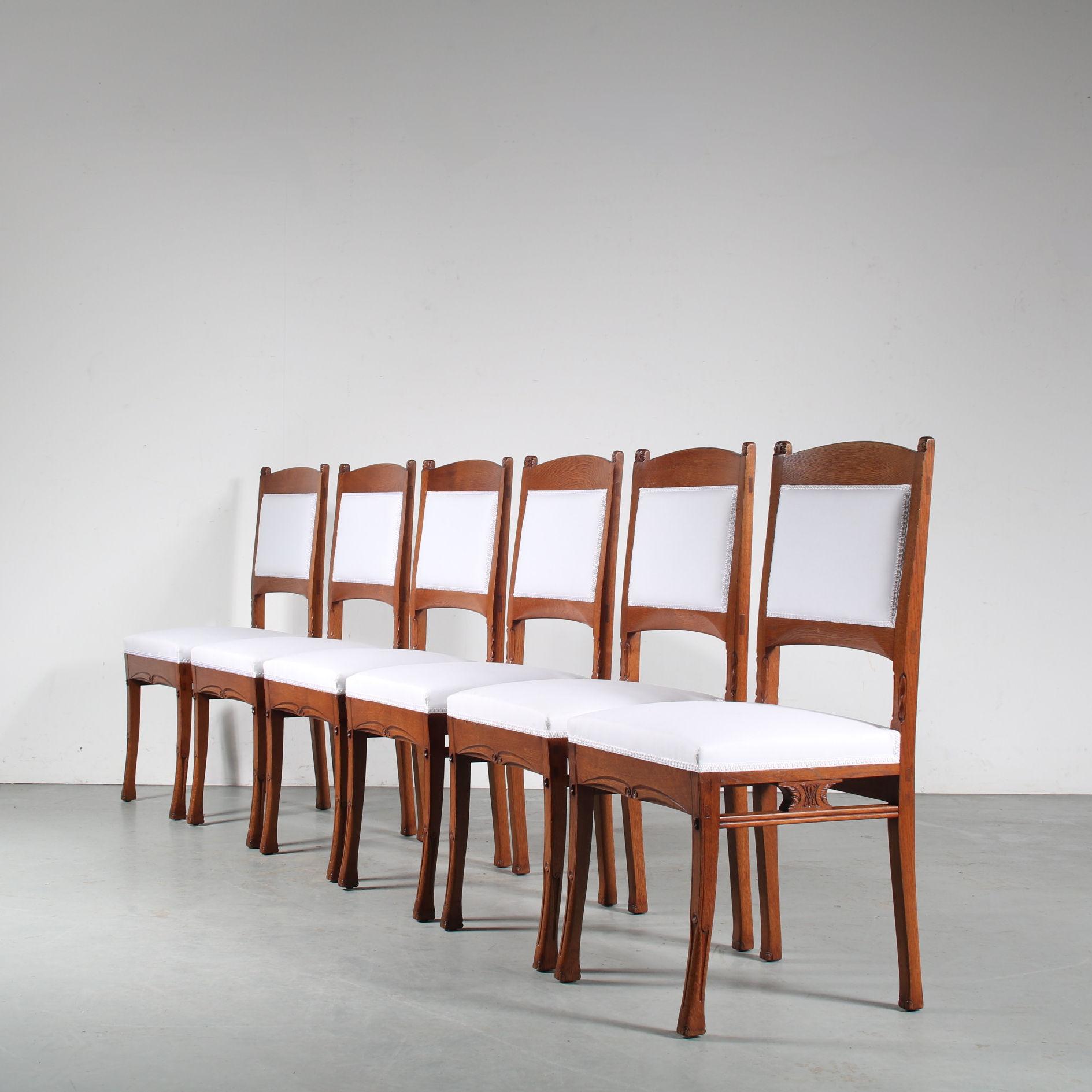 A beautiful set of dining chairs designed by Gerrit Willem Dijsselhof, manufactured by Van Wisselingh in Amsterdam, the Netherlands around 1900.

Made of high quality oak wood in a beautiful warm brown colour, these eye-catching pieces have an