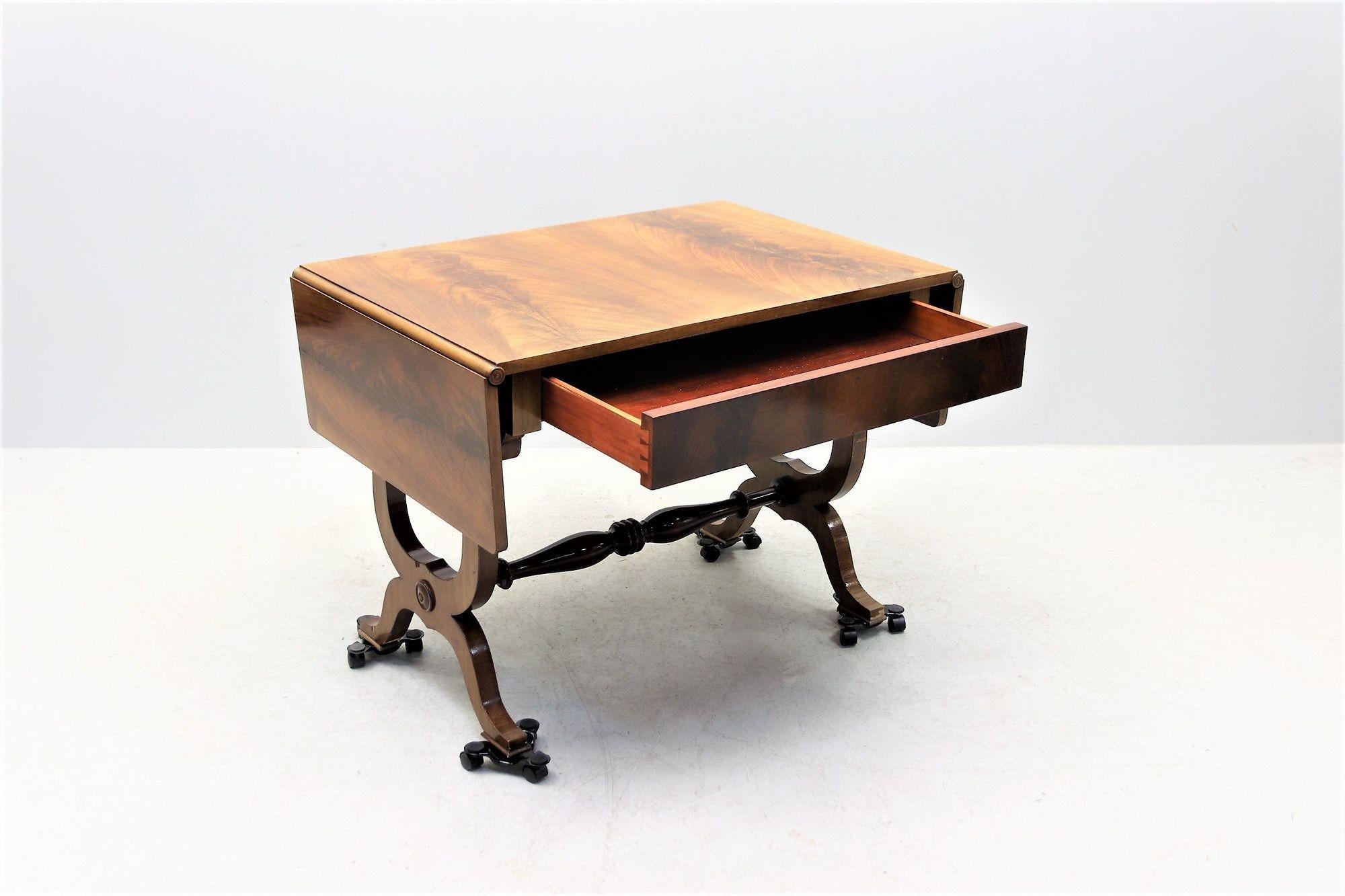 1900s Empire-style desk with gorgeous veneer wood grain detail and graceful carved legs. Dress up a home office or bedroom with this early 1900s empire-style hardwood desk with two collabsible, fold-down leaves. The wood grain detail of the desk top