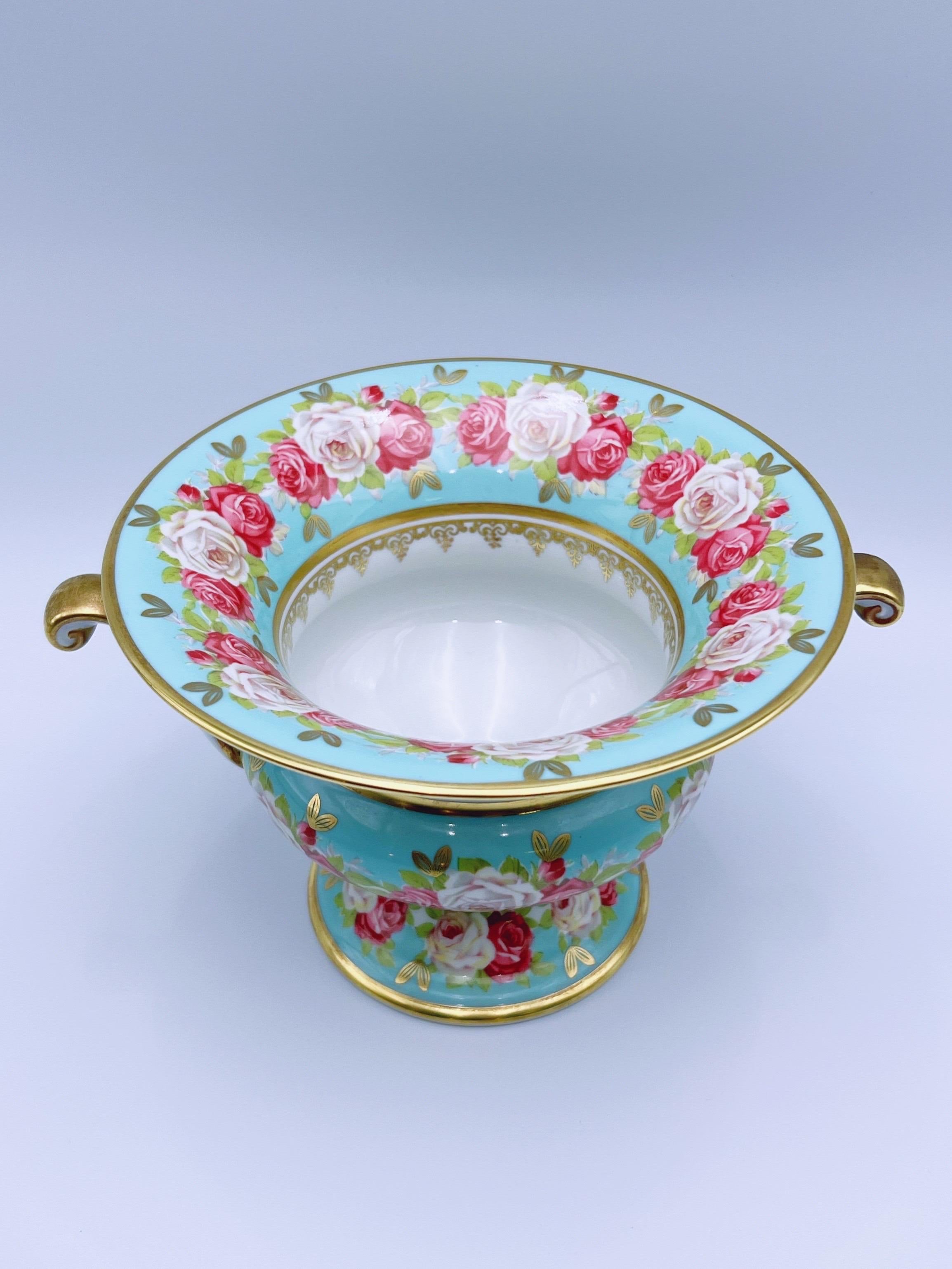 Elegante vaso a urna stile impero vintage di Rudolf Wächter, anni '60

Uno splendido vaso a urna o vaso jardinière in stile Impero in porcellana smaltata, ornato da squisite decorazioni a rose che circondano il corpo e il bordo. Lussuosi accenti