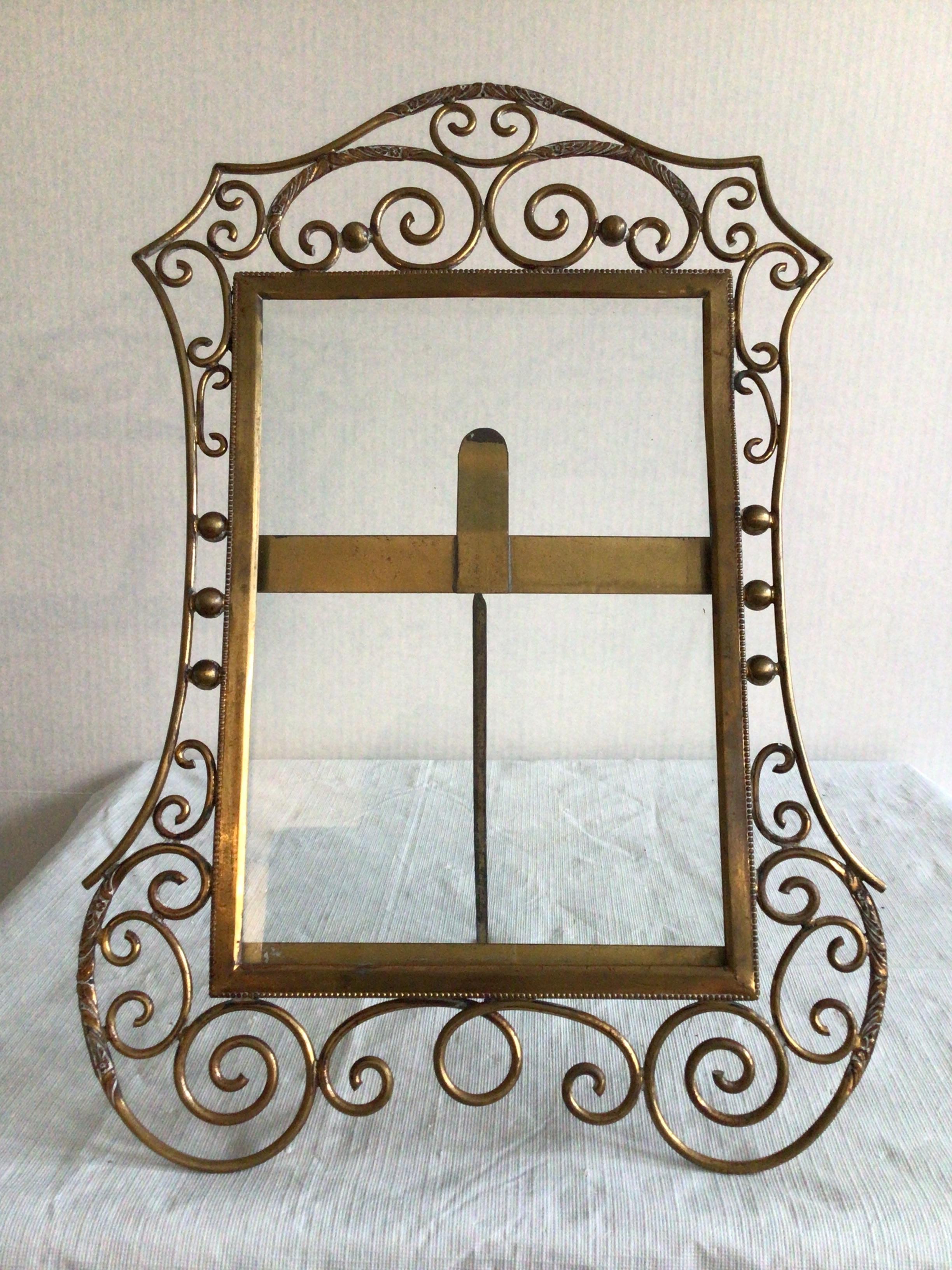 This 1900s English Brass Scrolled Picture Frame features C-scroll corners that are embossed with more intricate patterning as well as along the top portions of the frame
Border edge features a decorative and fine metal bead
Clear glass included (as