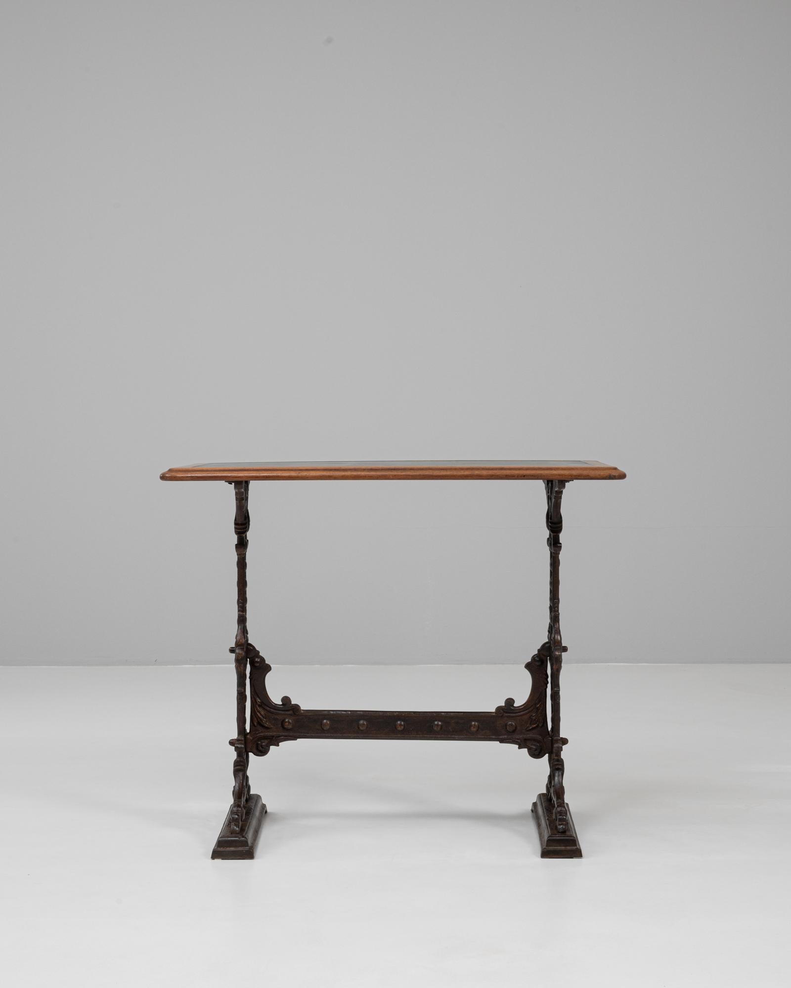 This 1900s English Cast Iron Pub Table by Gaskell & Chambers is a fine example of industrial craftsmanship blended with decorative design. Featuring an ornate cast iron base with intricate scrollwork and Gothic-inspired motifs, the table exudes