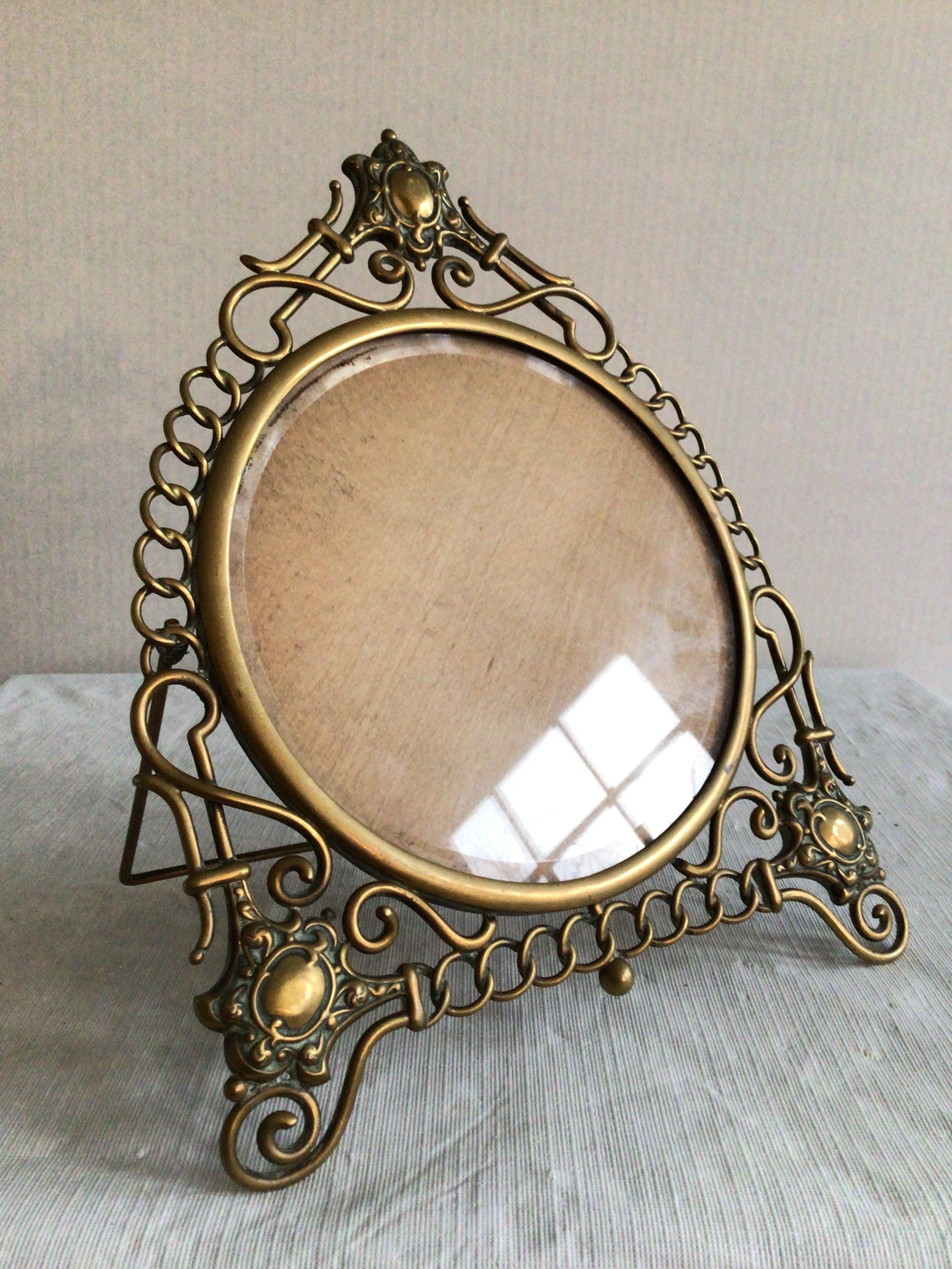 1900's English Scrolled Brass Circular Picture Frame with Medallion Accents
Depth give is with stand extended
Clear Beveled Glass With A Wood Back
Stand to be reattached, as shown in picture
