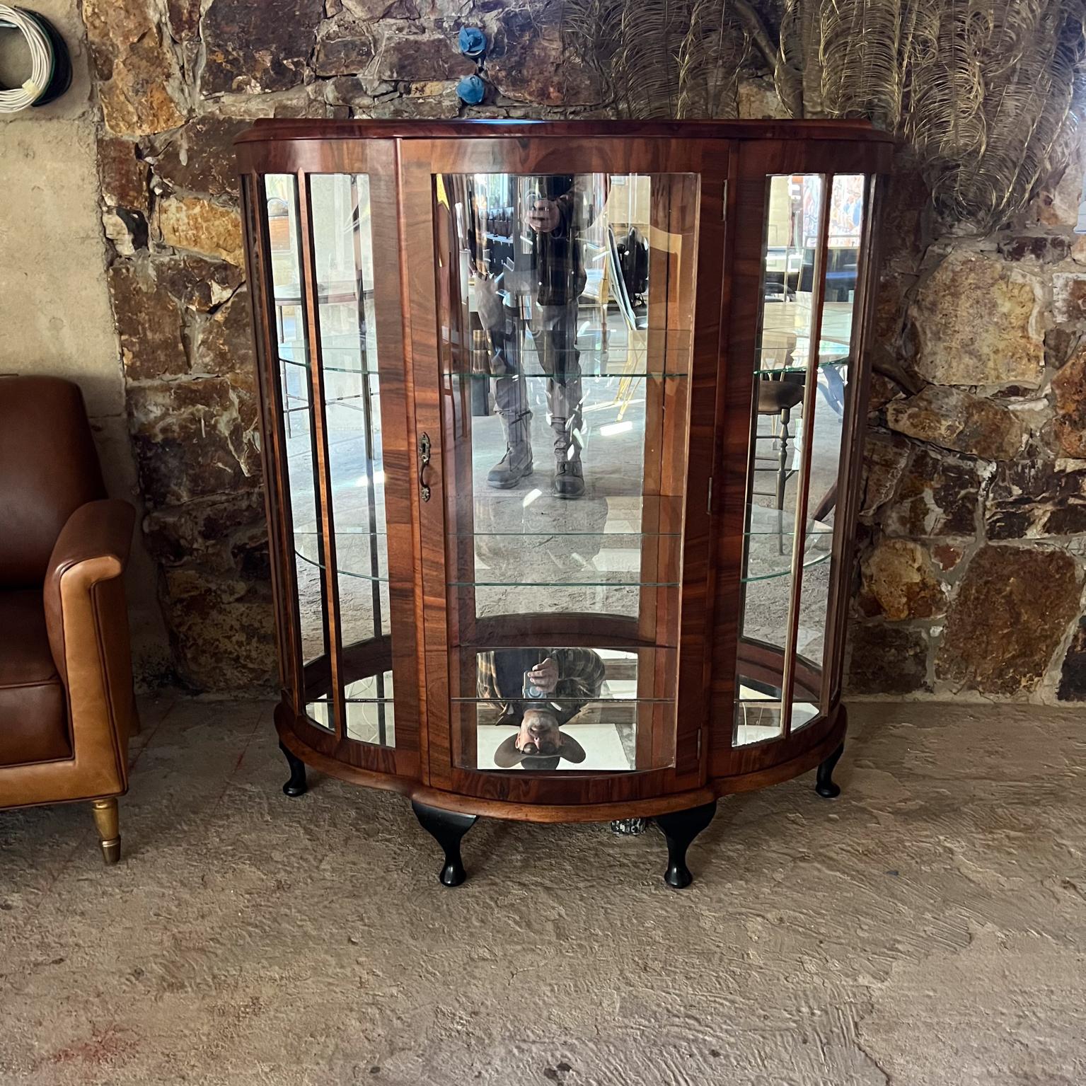 1900s Art Deco Curio Display Vitrine Cabinet Exotic Wood
No label
Cariole legs, Curved demilune Glass, Exotic Walnut Rosewood
New glass shelves retrofitted back mirror panel.
Wood has been restored. Glass in good shape.
Missing front lock key.
Firm