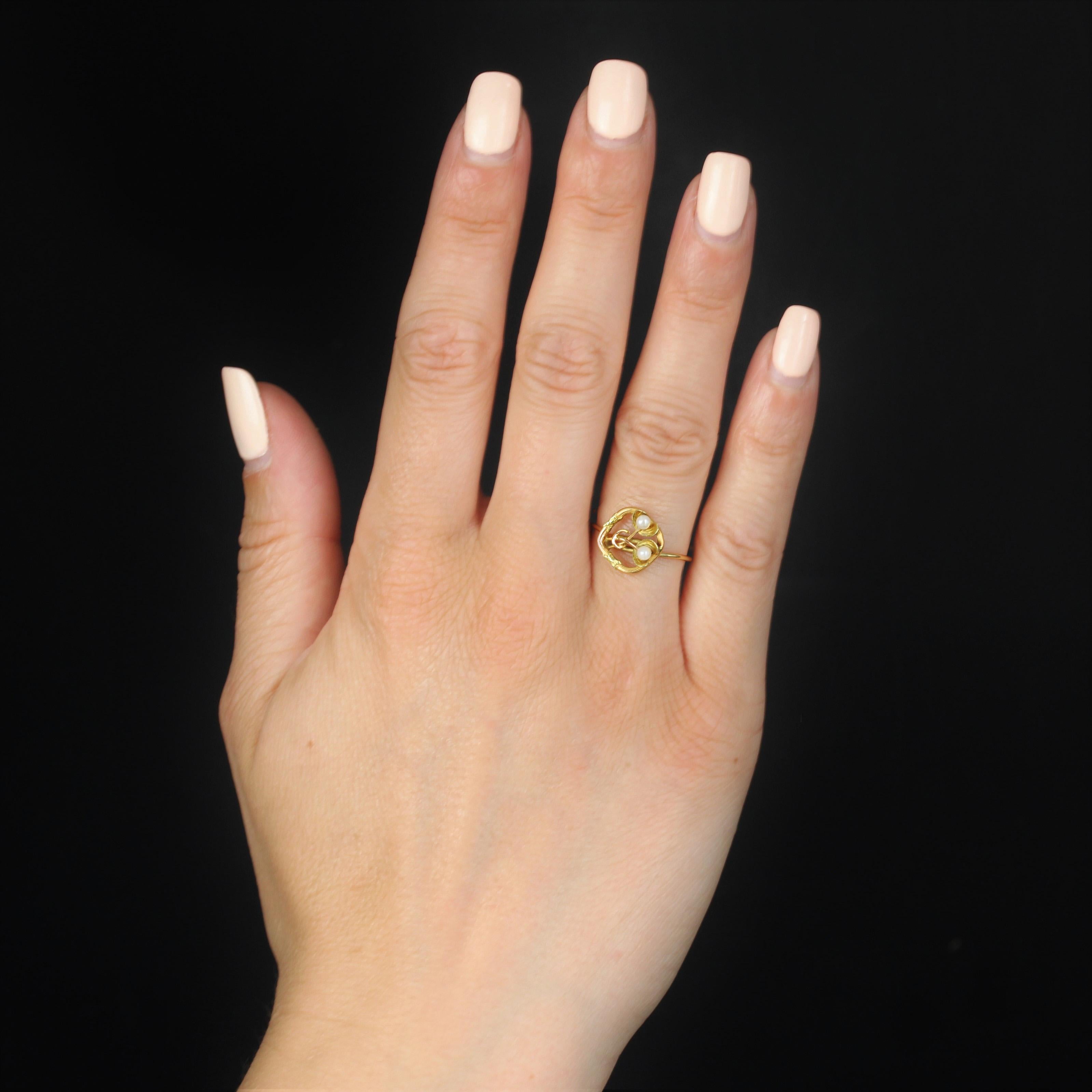 Ring in 18 karat yellow and rose gold.
This elegant antique ring is made of rose gold wire forming an openwork lozenge, the center of which is adorned with 2 flowers with yellow gold leaves, and the center set with a small fine pearl. Two cross