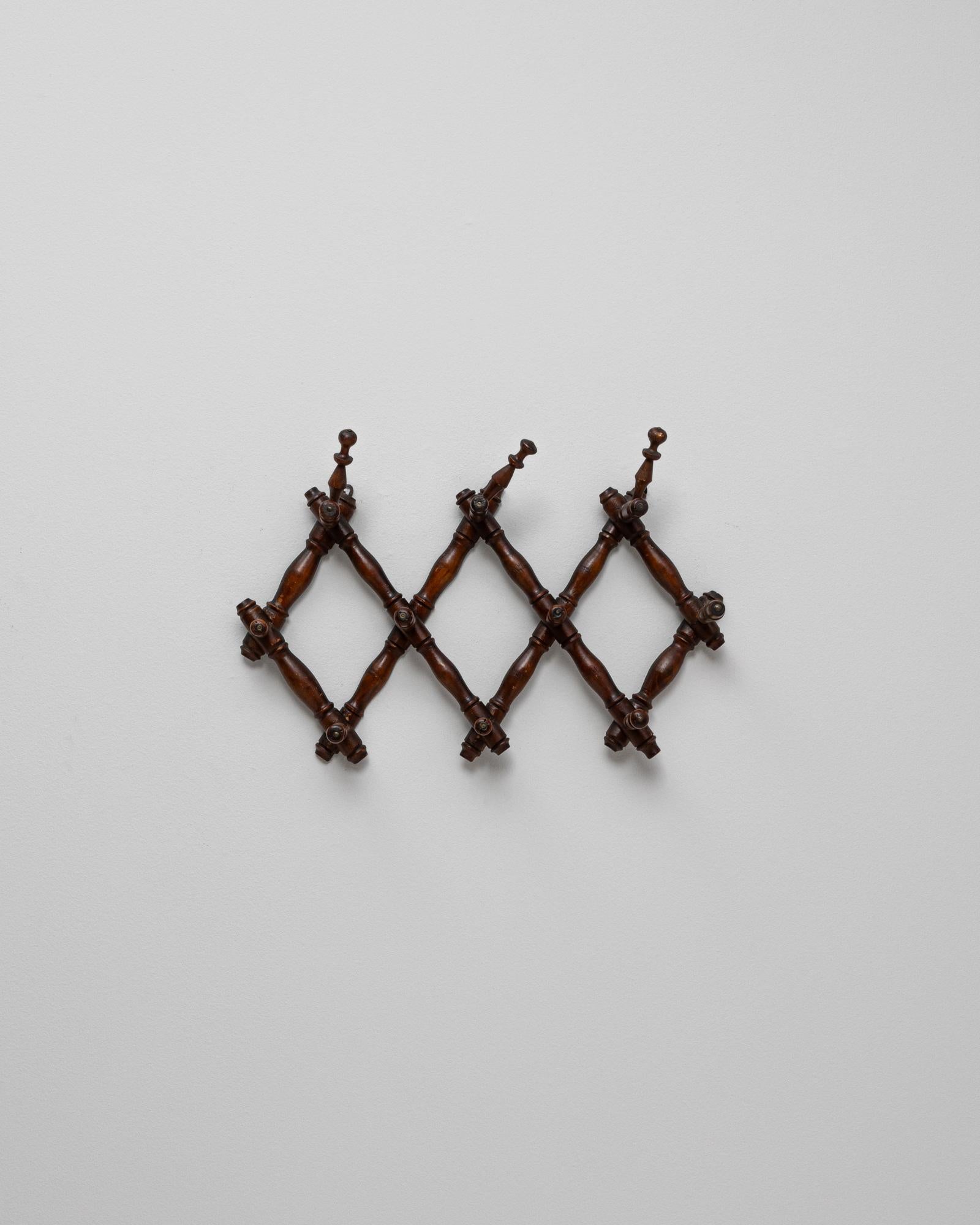 Appendiabiti da parete in finto bambù francese del 1900. Questo elegante appendiabiti da parete è caratterizzato da un design a fisarmonica espandibile realizzato in legno riccamente patinato e intagliato con un motivo di finto bambù. Riflettendo il