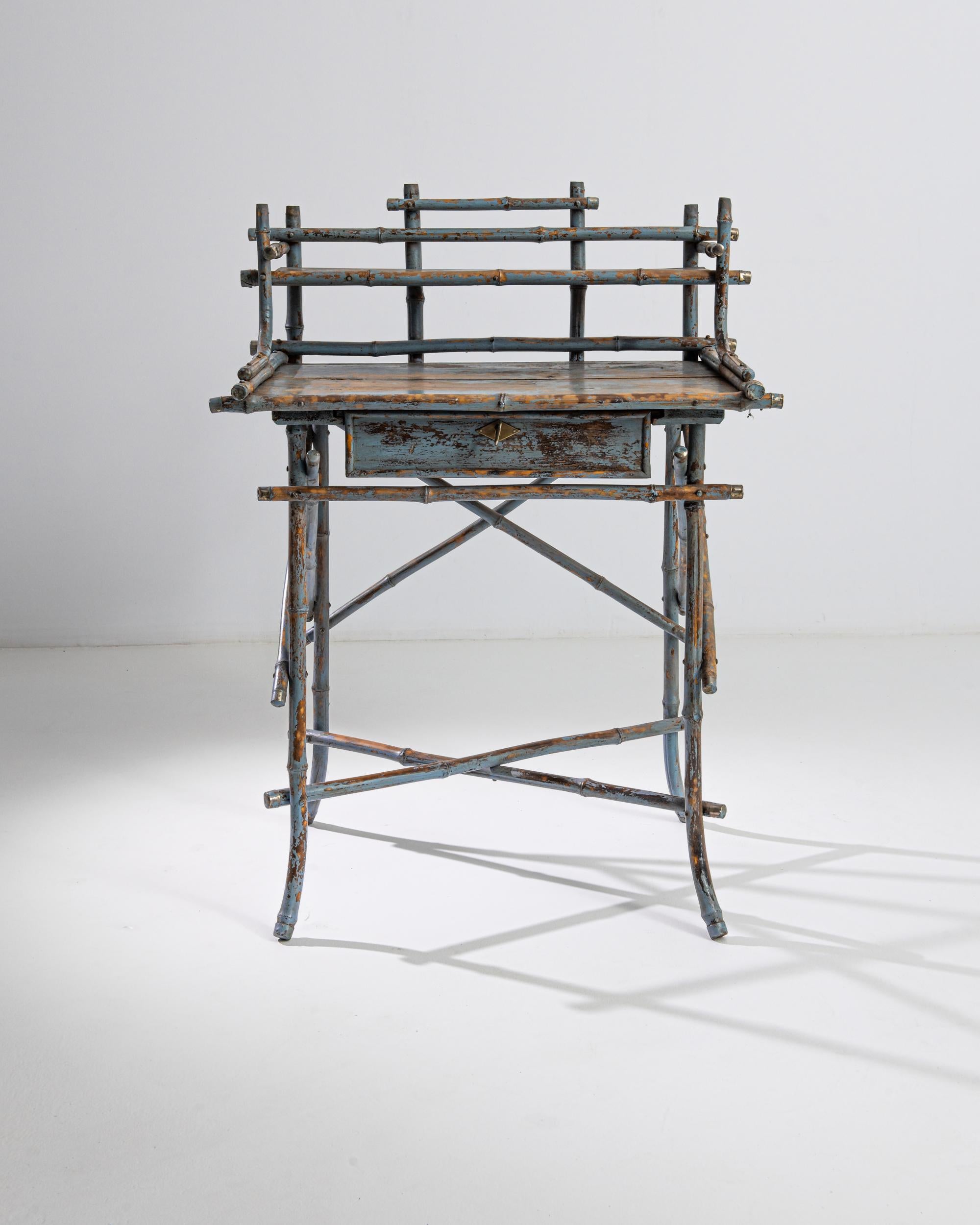 This one of a kind antique desk was produced in France, circa 1900. A wooden desk with a bamboo frame, this aerial piece recalls a scaffolding structure, balanced in an audacious composition. The desk features a small front drawer adorned with a