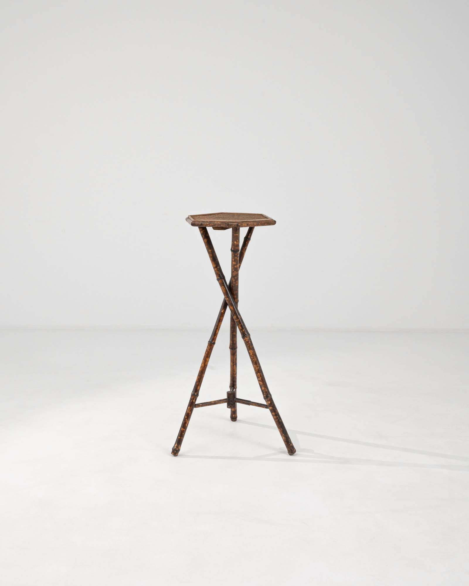 This 1900s French Bamboo Pedestal embodies the elegance and simplicity of classic design. The natural bamboo construction offers a lightweight yet robust frame, highlighted by the charming wear that reveals its century-old story. Its cross-braced