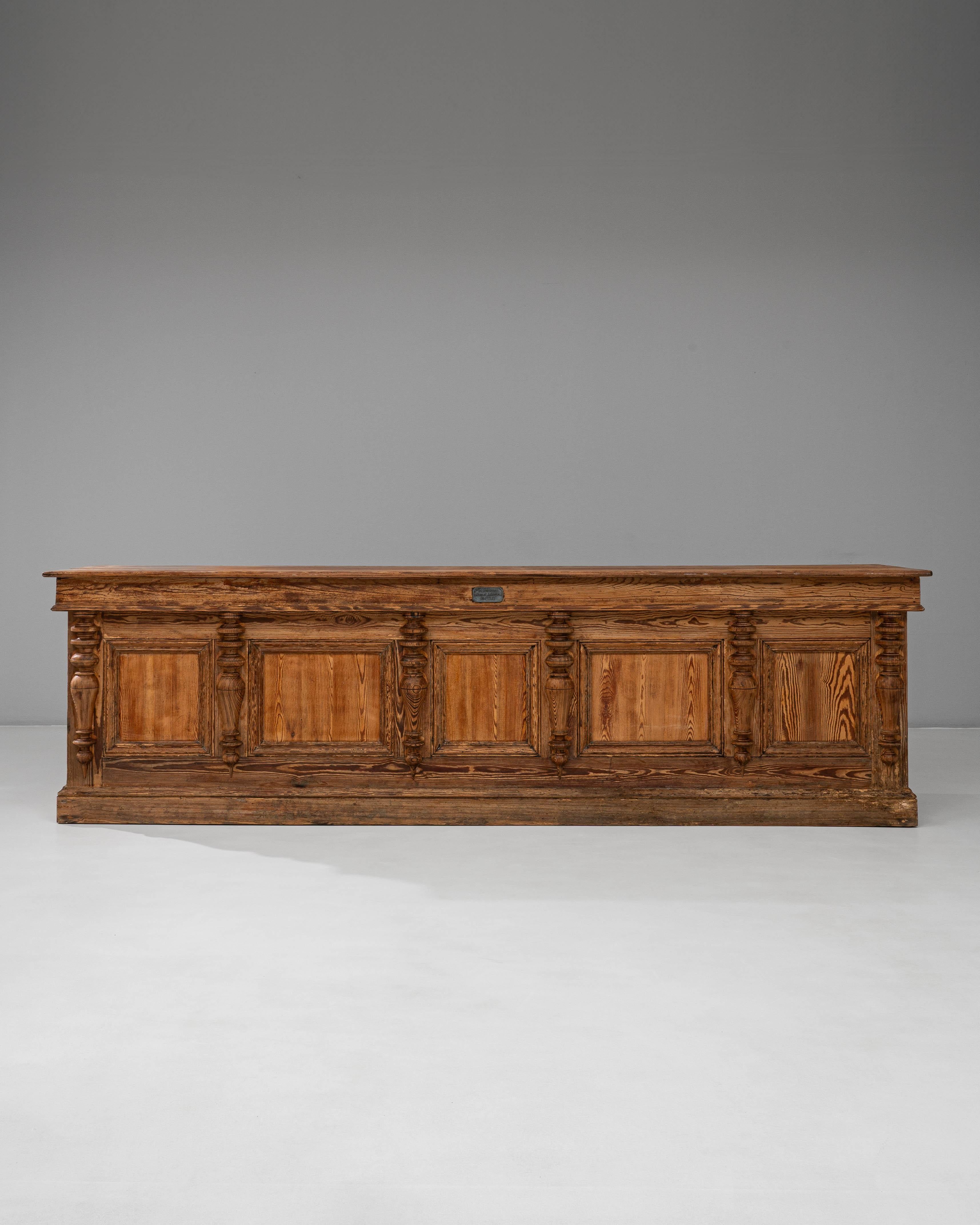 Este excepcional mostrador de tienda de madera de estilo provincial belga francés de 1900, obra de Emile Lambot de Châtelet, muestra una artesanía exquisita y un diseño atemporal. Construida en madera maciza con ricas vetas naturales, la pieza