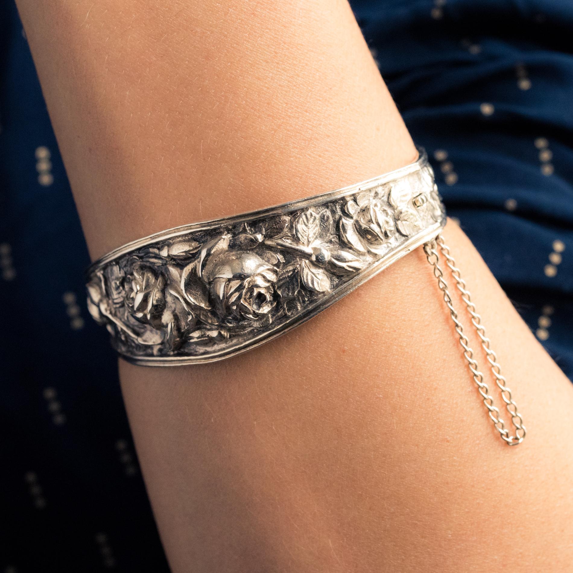 Bracalet in silver, boar's head hallmark.
Rigid bangle bracelet, it is adorned all around with bouquets of chiseled roses. The upper part is wider. It opens with a hinge on the side. The clasp is ratchet with safety chain.
Internal circumference :