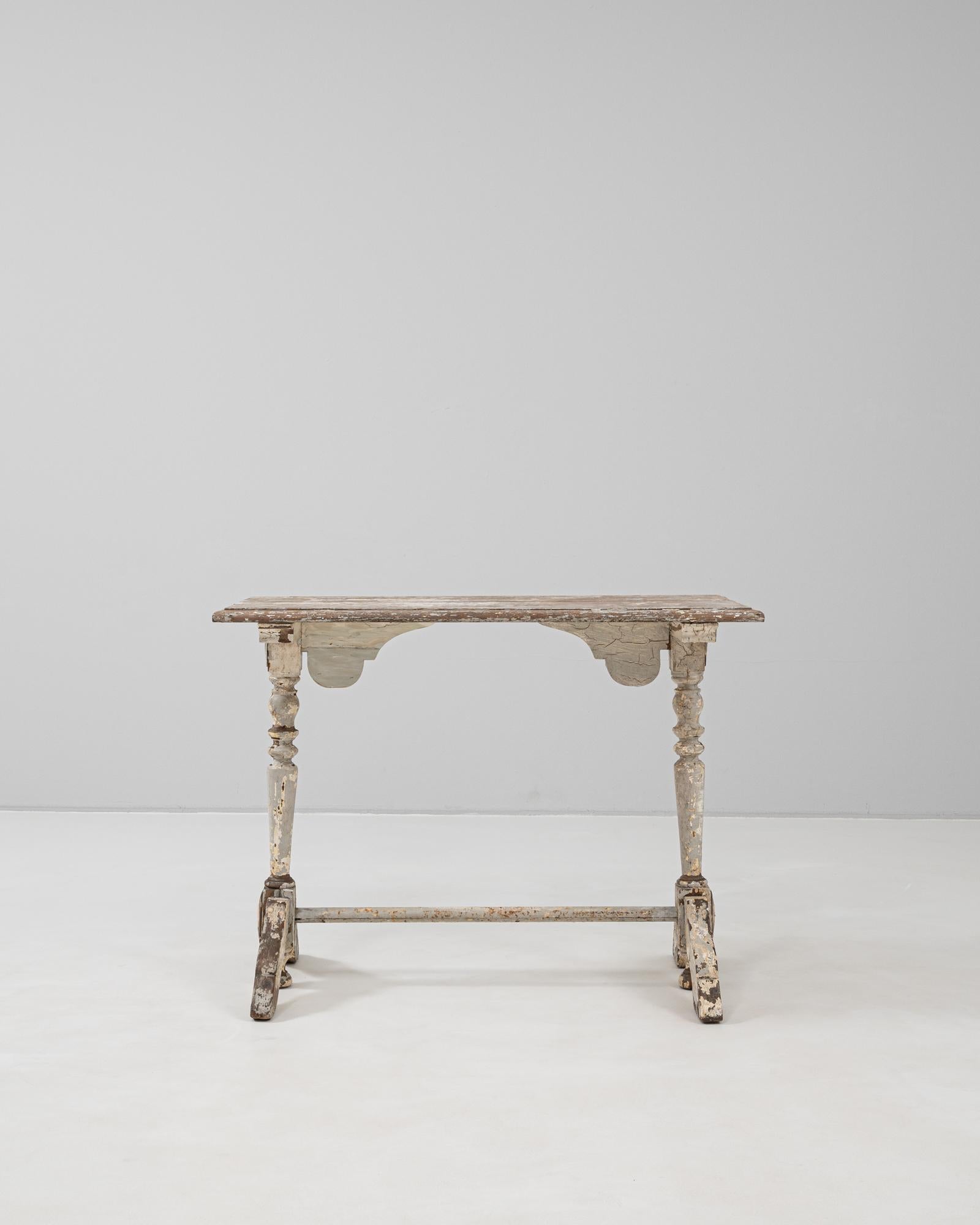This 1900s French bistro table captures the enduring charm of early café culture with its sculpted wooden base and beautifully weathered patina. The table retains its original layers of paint, now naturally distressed over time, revealing traces of