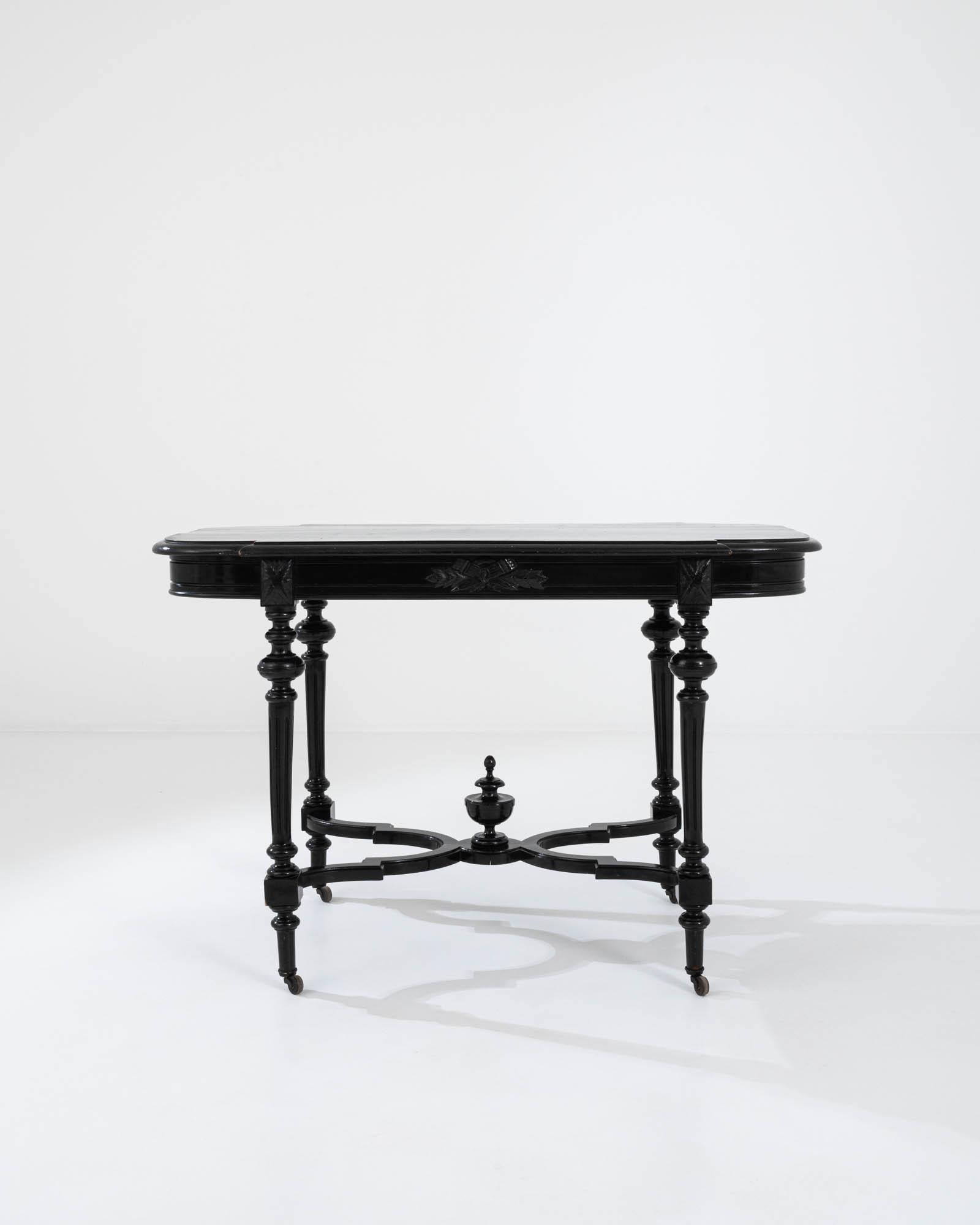 A wooden table on wheels created in 1900s France. A dazzling display of eye-pleasing curves, shapes, and tapering appendages, this classical table beams with astute and formal beauty. The sumptuously lathed legs descend down to gracefully join with