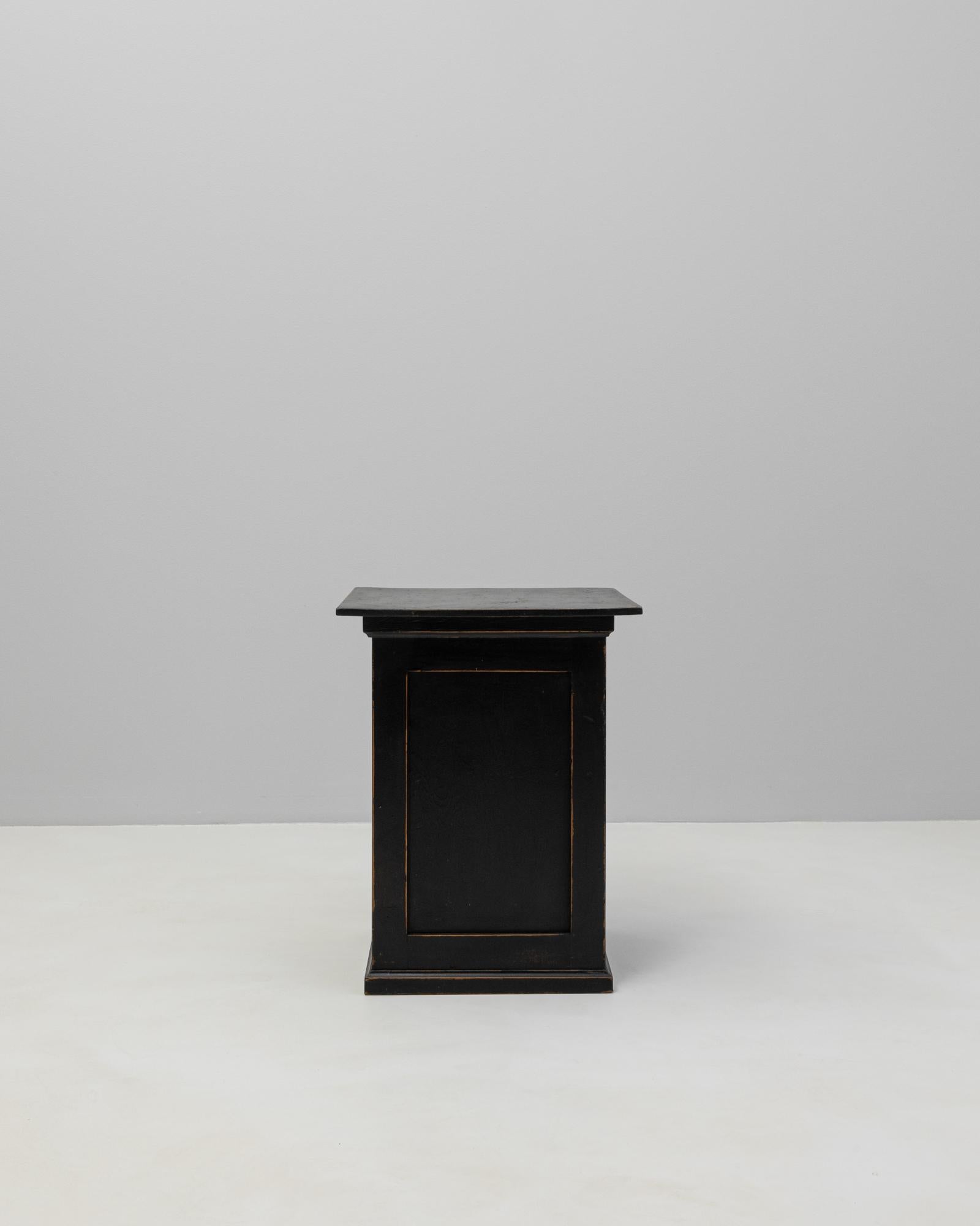 Piédestal en bois patiné noir des années 1900, aux lignes épurées et à la finition subtilement vieillie qui révèle les nuances du bois naturel. Fabriquée avec des panneaux latéraux et une partie supérieure légèrement en surplomb, cette pièce allie